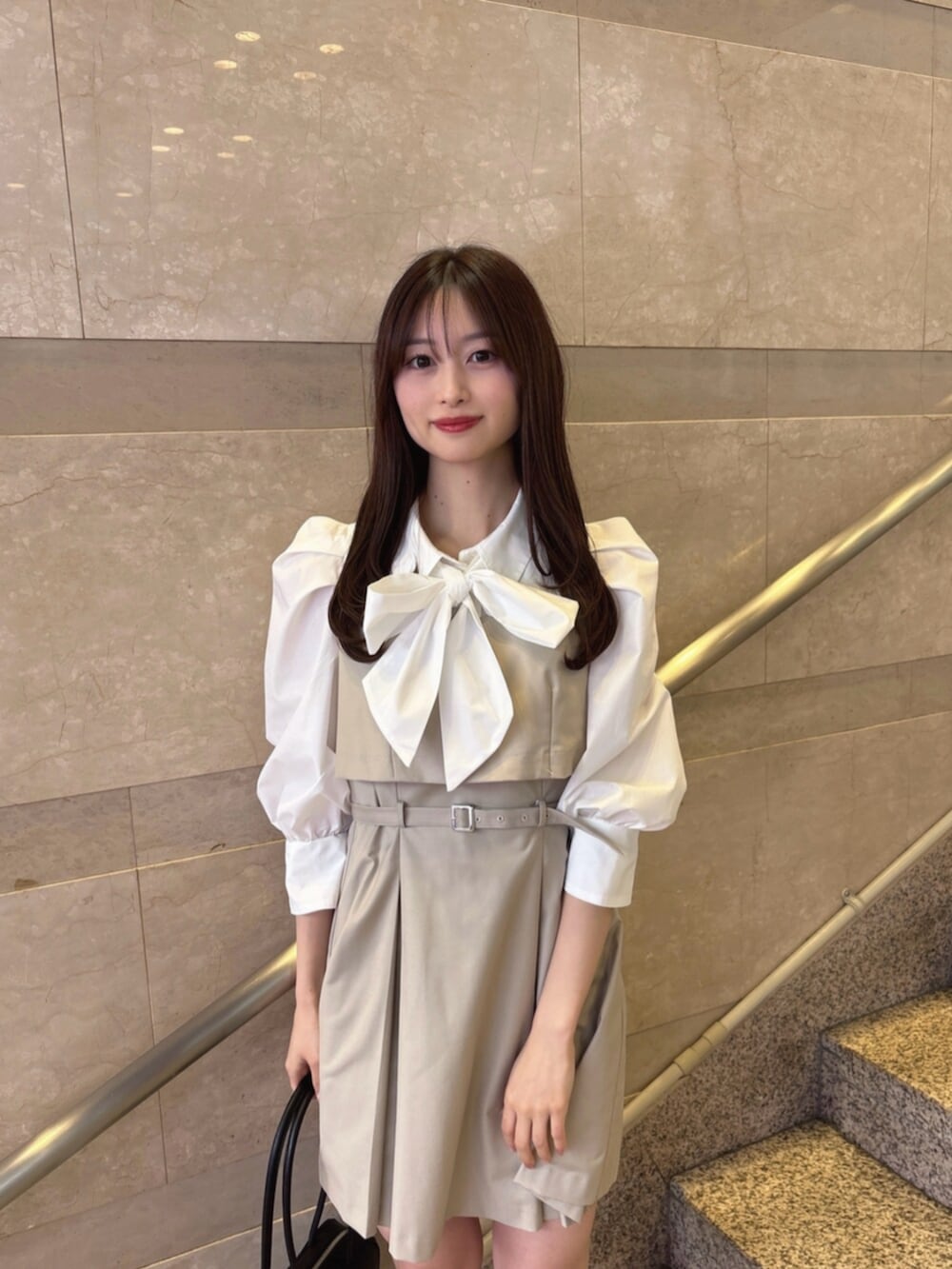 ベージュ系のワンピース、ブラック系のハンドバッグ、ブラック系のパンプスを着用したレディースの春コーディネートの5枚目の写真