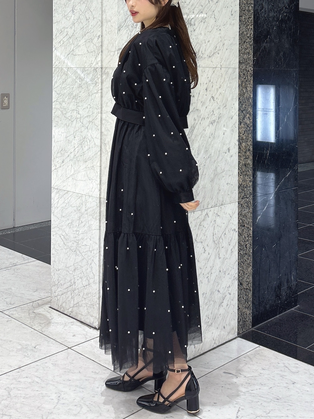 ブラック系のワンピース、ブラック系のブルゾン、ブラック系のサンダルを着用したレディースの春コーディネートの4枚目の写真