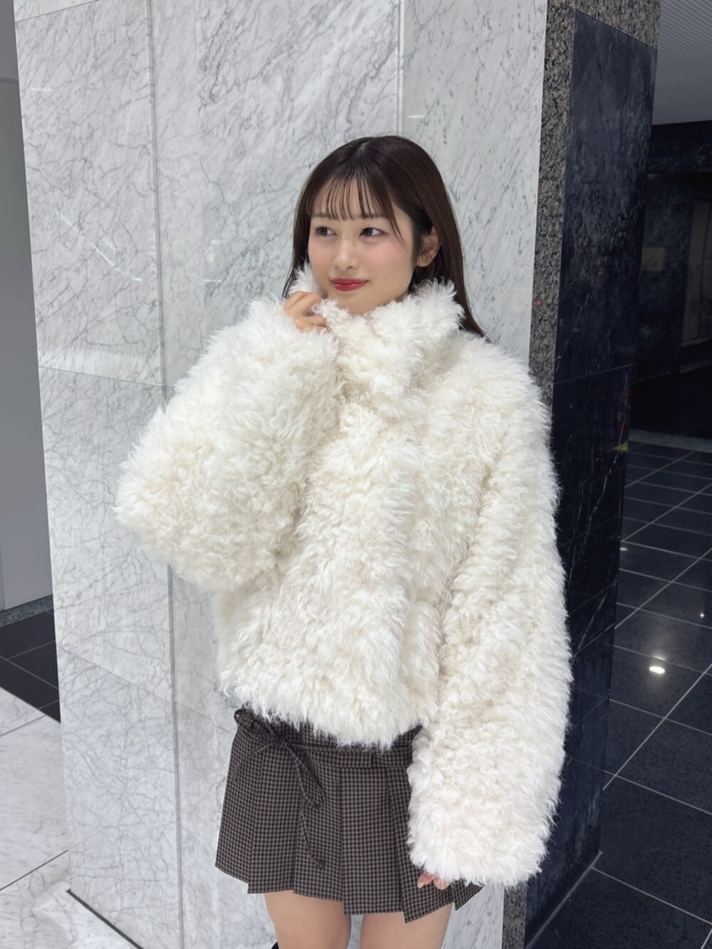 ブラック系のブーツ、ホワイト系のブルゾンを着用したレディースの秋コーディネートの6枚目の写真