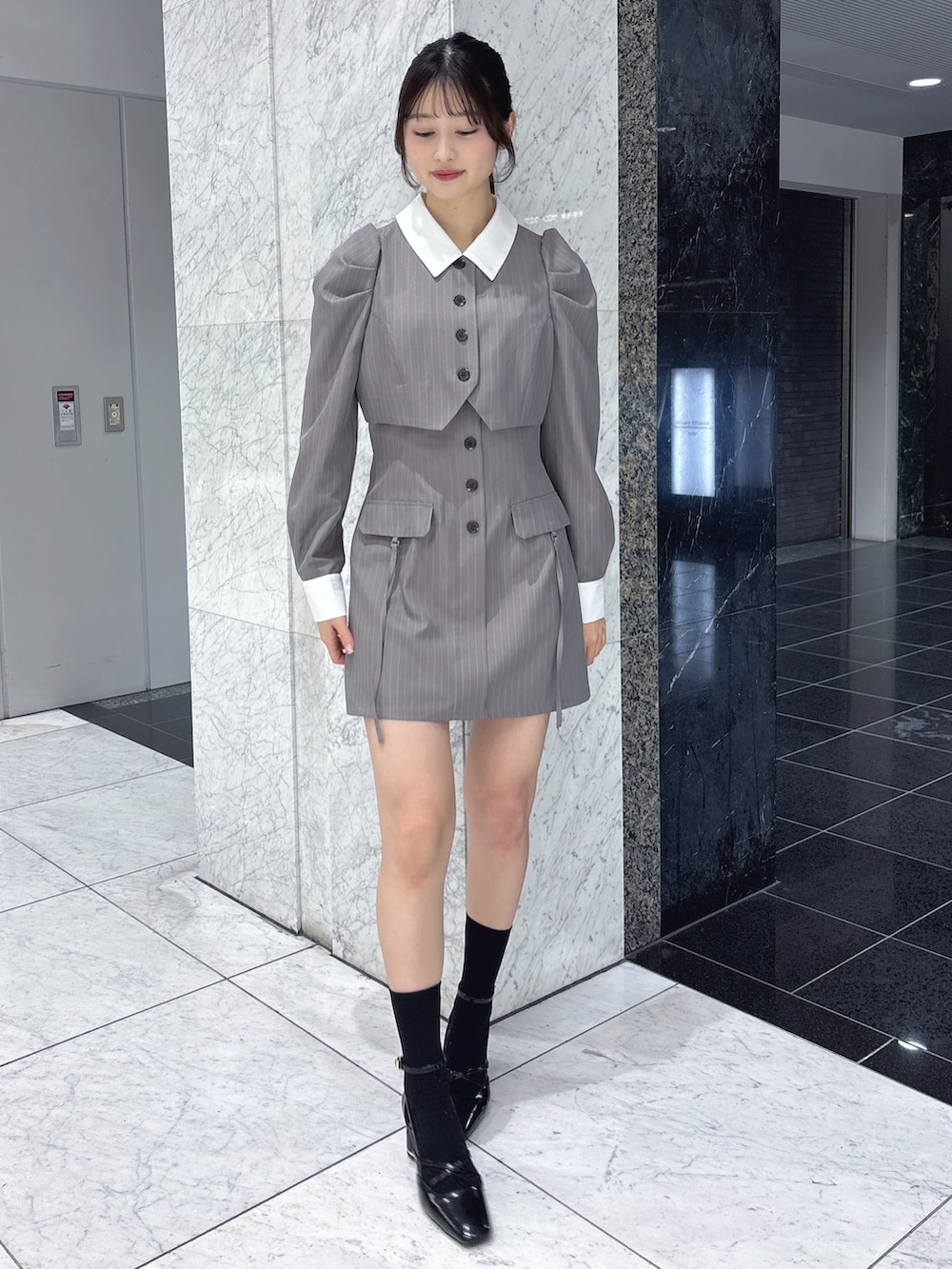 グレー系のワンピース、ブラック系のサンダルを着用したレディースの冬コーディネートの2枚目の写真