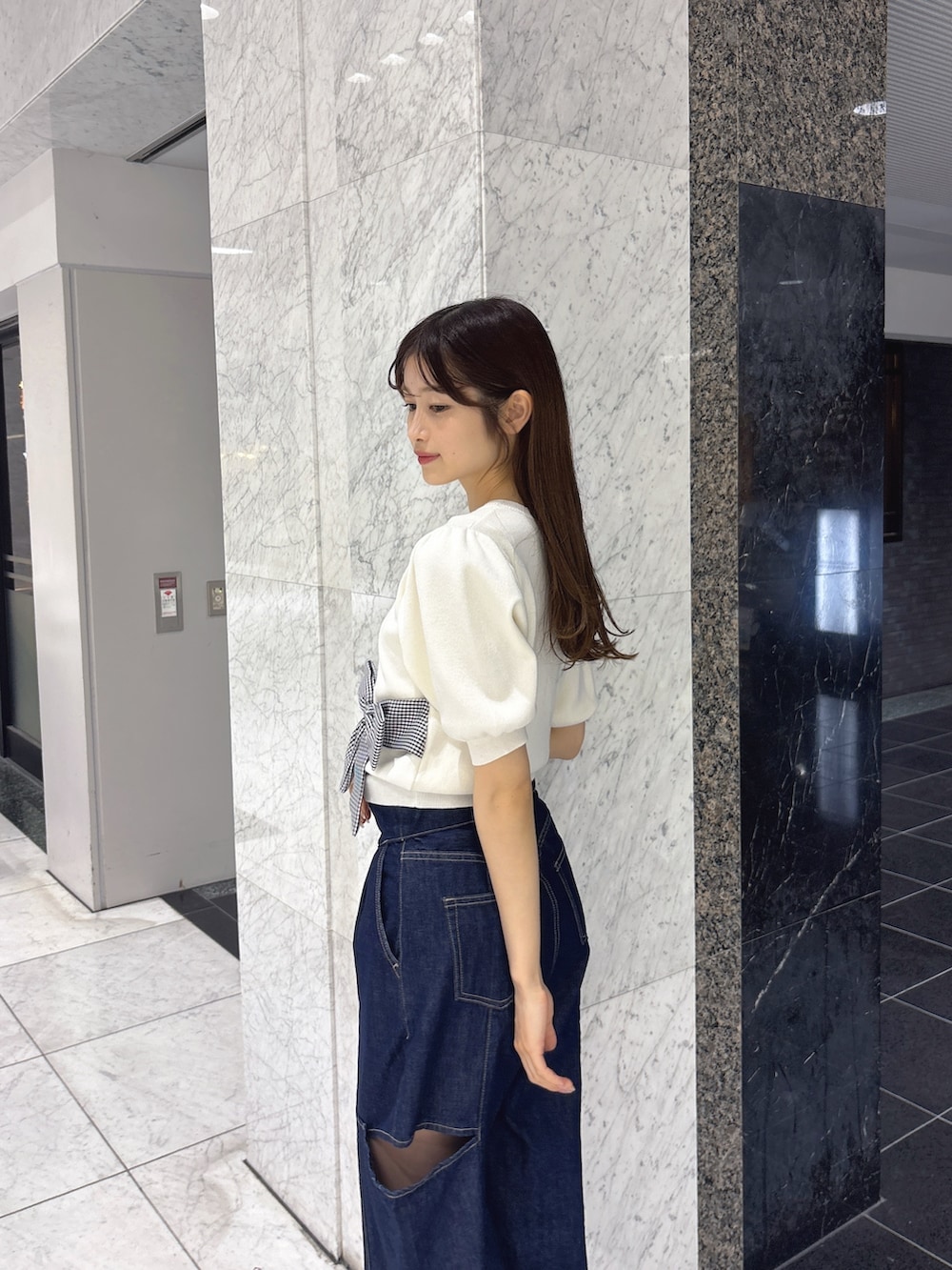 ブルー系のデニムパンツ、ホワイト系のサンダル、ホワイト系のニット/セーターを着用したレディースの春コーディネートの5枚目の写真