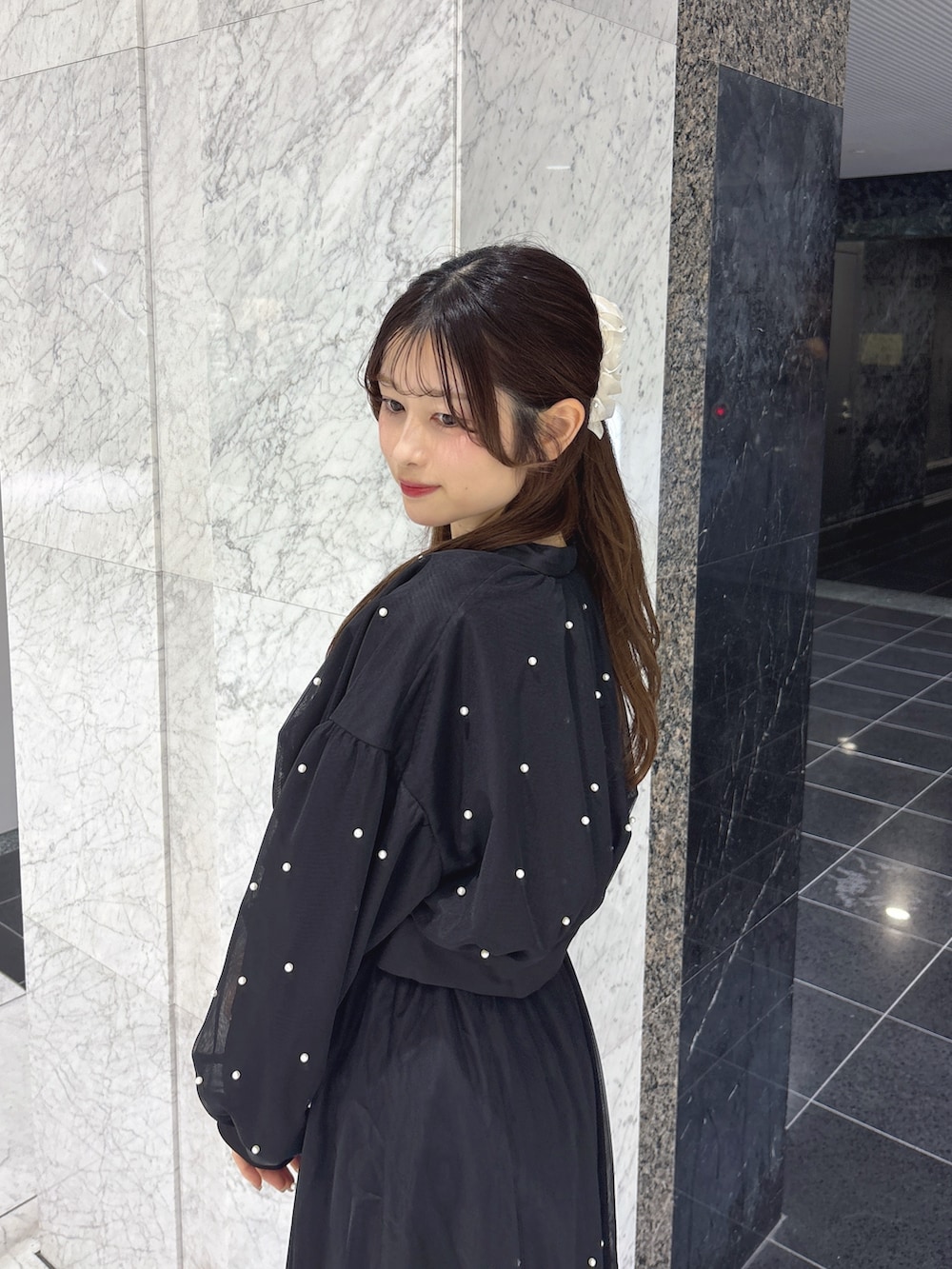 ブラック系のワンピース、ブラック系のブルゾン、ブラック系のサンダルを着用したレディースの春コーディネートの7枚目の写真