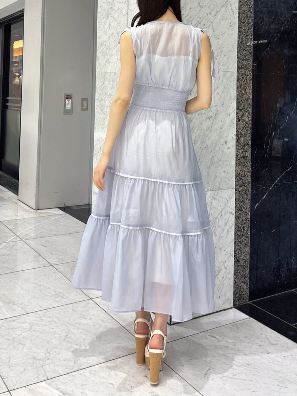 ホワイト系のサンダル、ブルー系のワンピースを着用したレディースの夏コーディネートの5枚目の写真