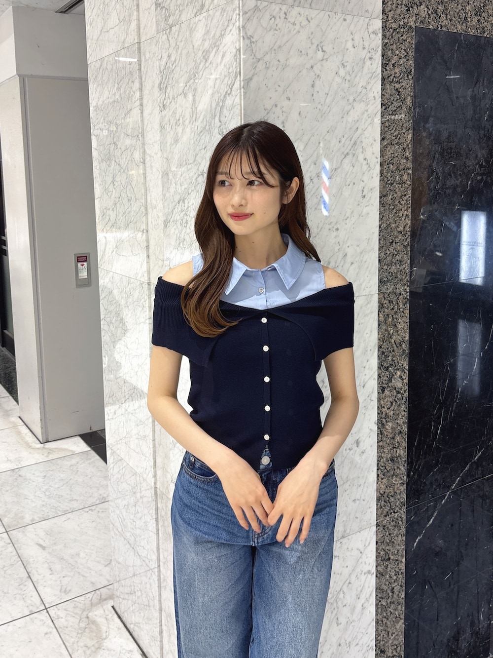 ブルー系のニット/セーター、ブルー系のデニムパンツ、ホワイト系のサンダルを着用したレディースの春コーディネートの4枚目の写真