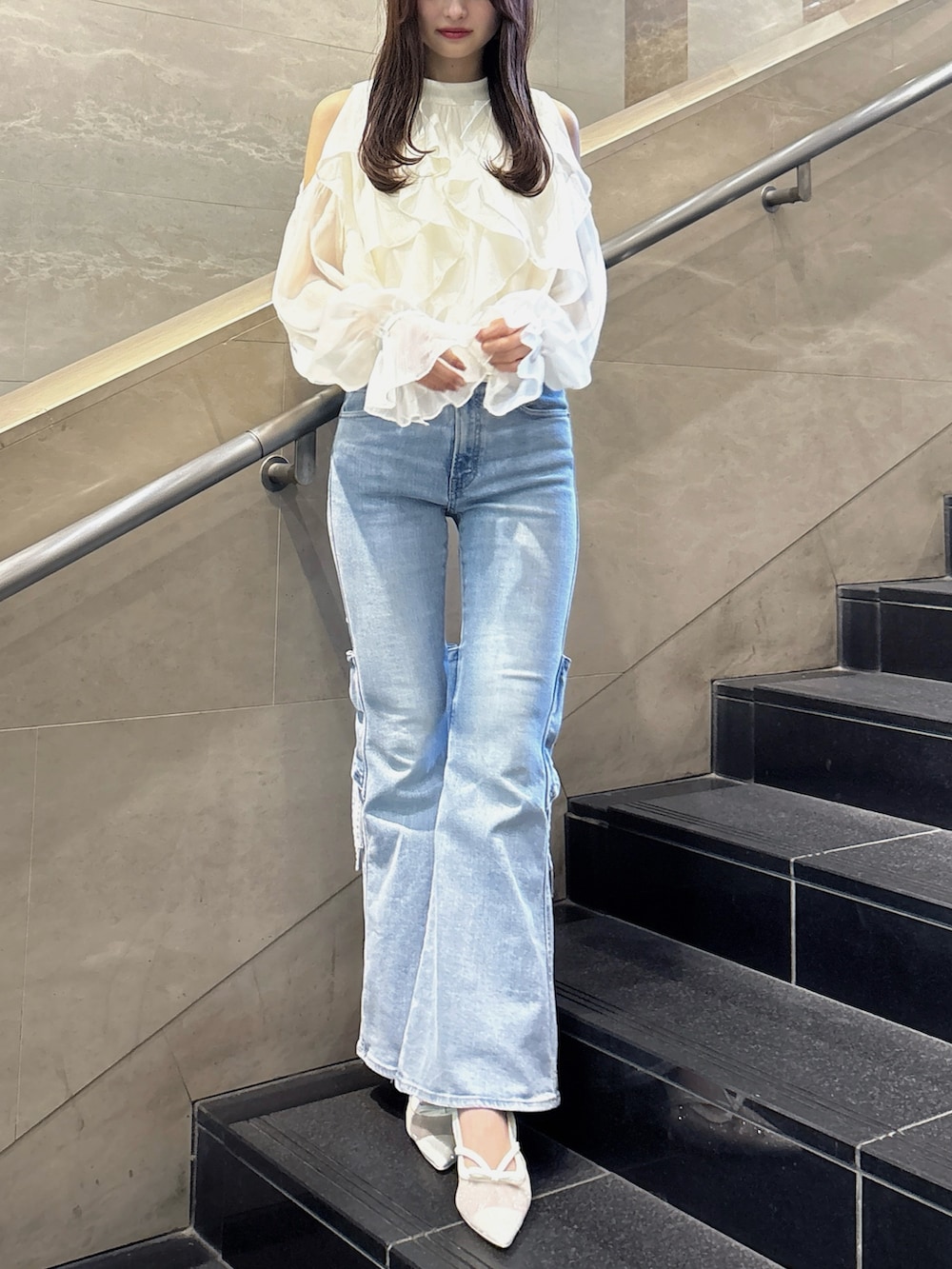 ブルー系のデニムパンツ、ホワイト系のシャツ/ブラウス、ホワイト系のパンプスを着用したレディースの春コーディネートの2枚目の写真