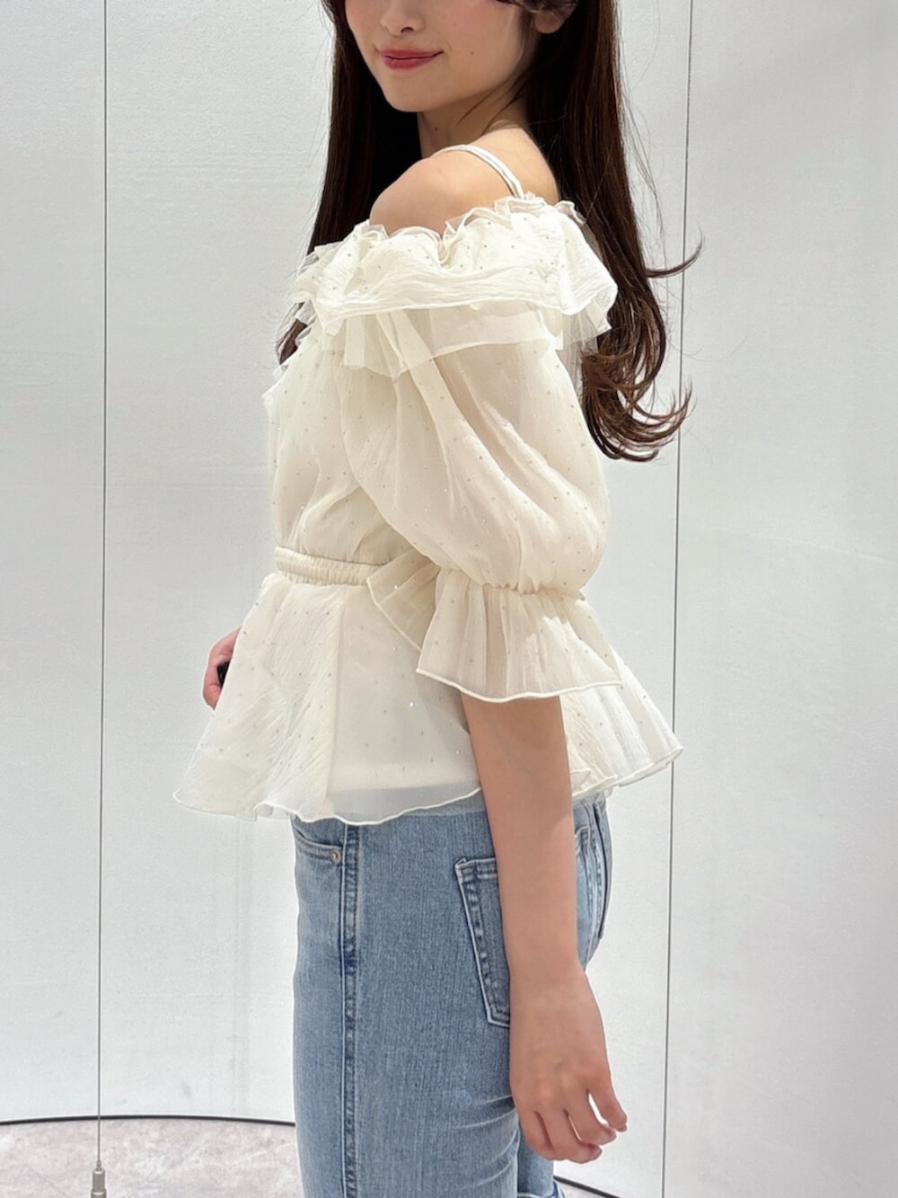 ブルー系のデニムパンツ、ホワイト系のパンプス、ホワイト系のシャツ/ブラウスを着用したレディースの春コーディネートの6枚目の写真