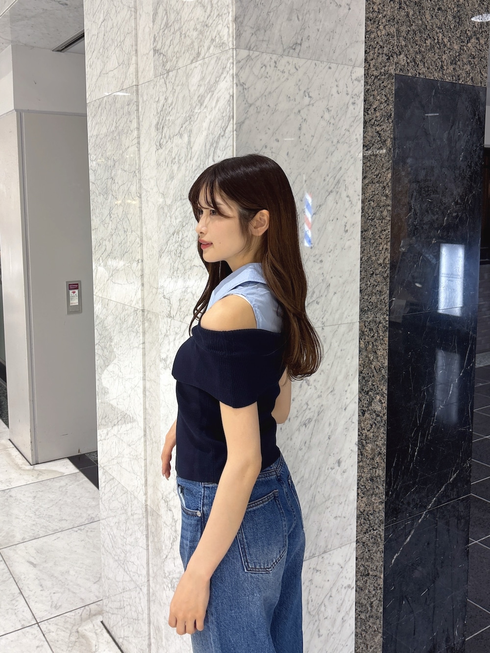 ブルー系のニット/セーター、ブルー系のデニムパンツ、ホワイト系のサンダルを着用したレディースの春コーディネートの6枚目の写真