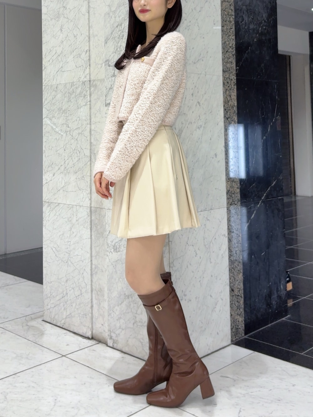 ホワイト系のスカート、ピンク系のノーカラージャケット、ブラウン系のブーツを着用したレディースの冬コーディネートの3枚目の写真