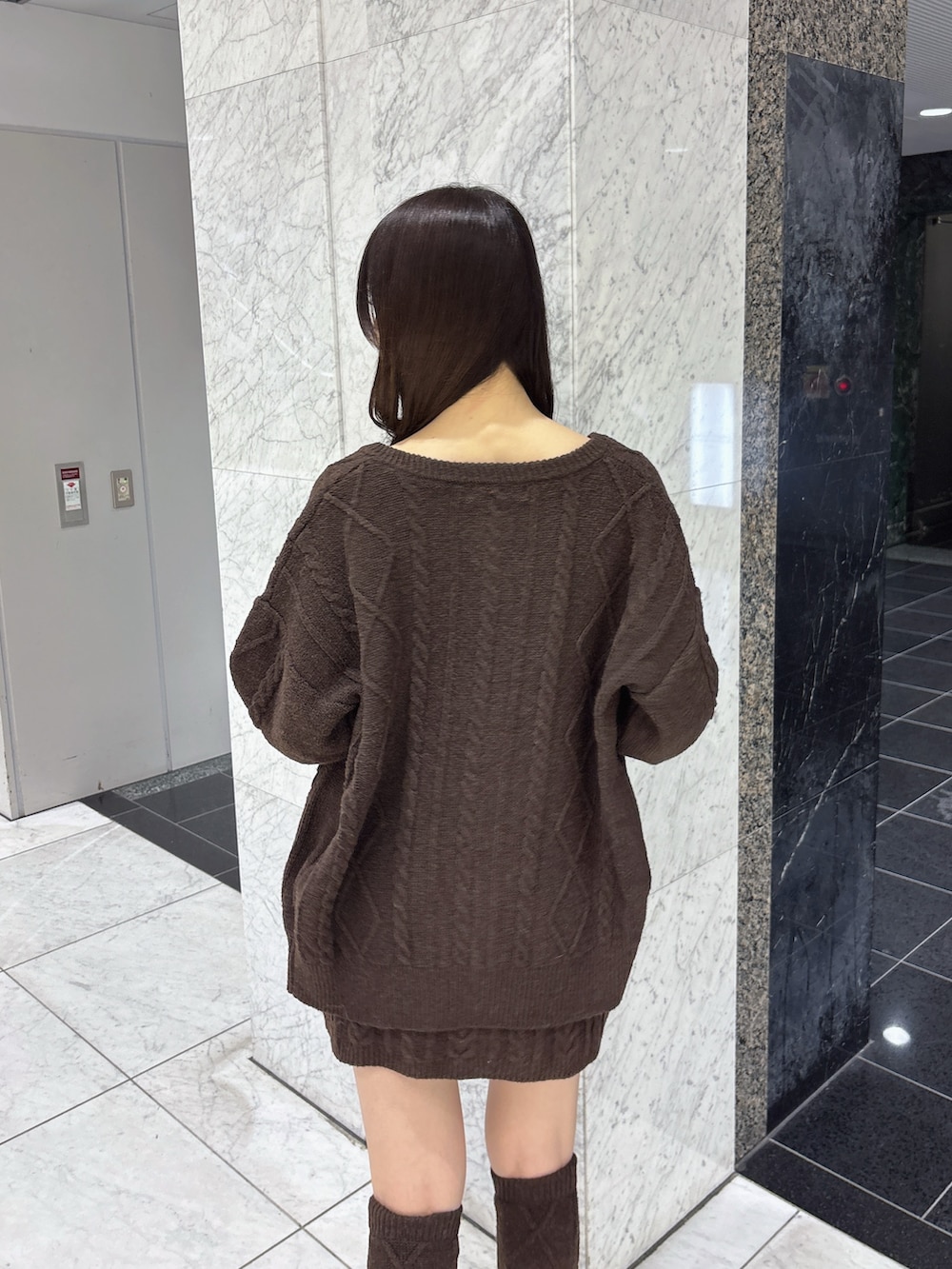 ブラウン系のカーディガン/ボレロ、ブラウン系のワンピース、ホワイト系のその他シューズを着用したレディースの秋コーディネートの6枚目の写真