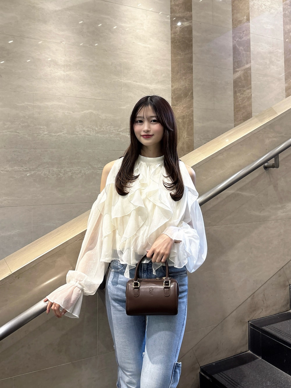 ブルー系のデニムパンツ、ホワイト系のシャツ/ブラウス、ホワイト系のパンプスを着用したレディースの春コーディネートの5枚目の写真