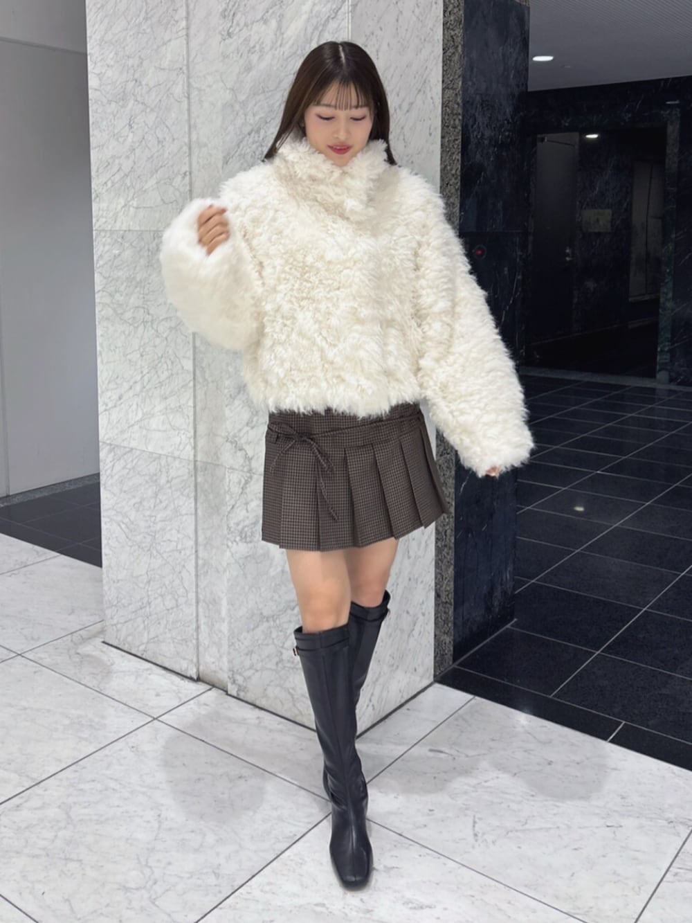 ブラック系のブーツ、ホワイト系のブルゾンを着用したレディースの秋コーディネートの2枚目の写真