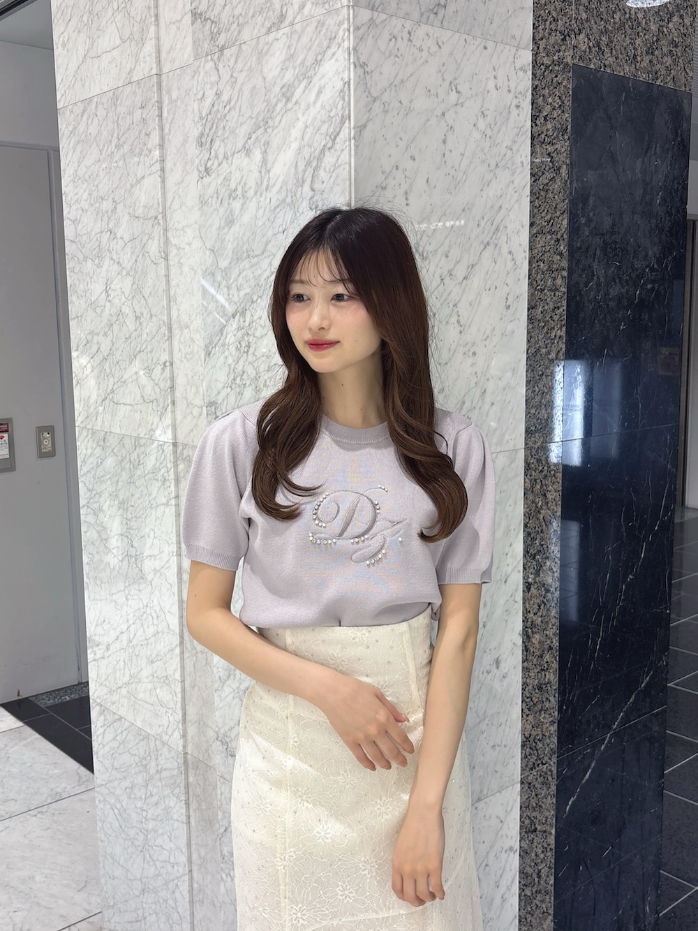 ホワイト系のスカート、グレー系のニット/セーター、ホワイト系のパンプスを着用したレディースの春コーディネートの5枚目の写真