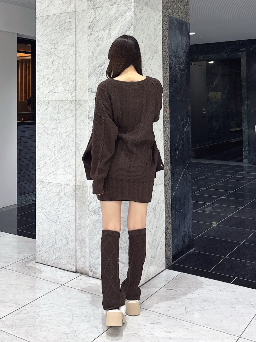 ブラウン系のカーディガン/ボレロ、ブラウン系のワンピース、ホワイト系のその他シューズを着用したレディースの秋コーディネートの4枚目の写真