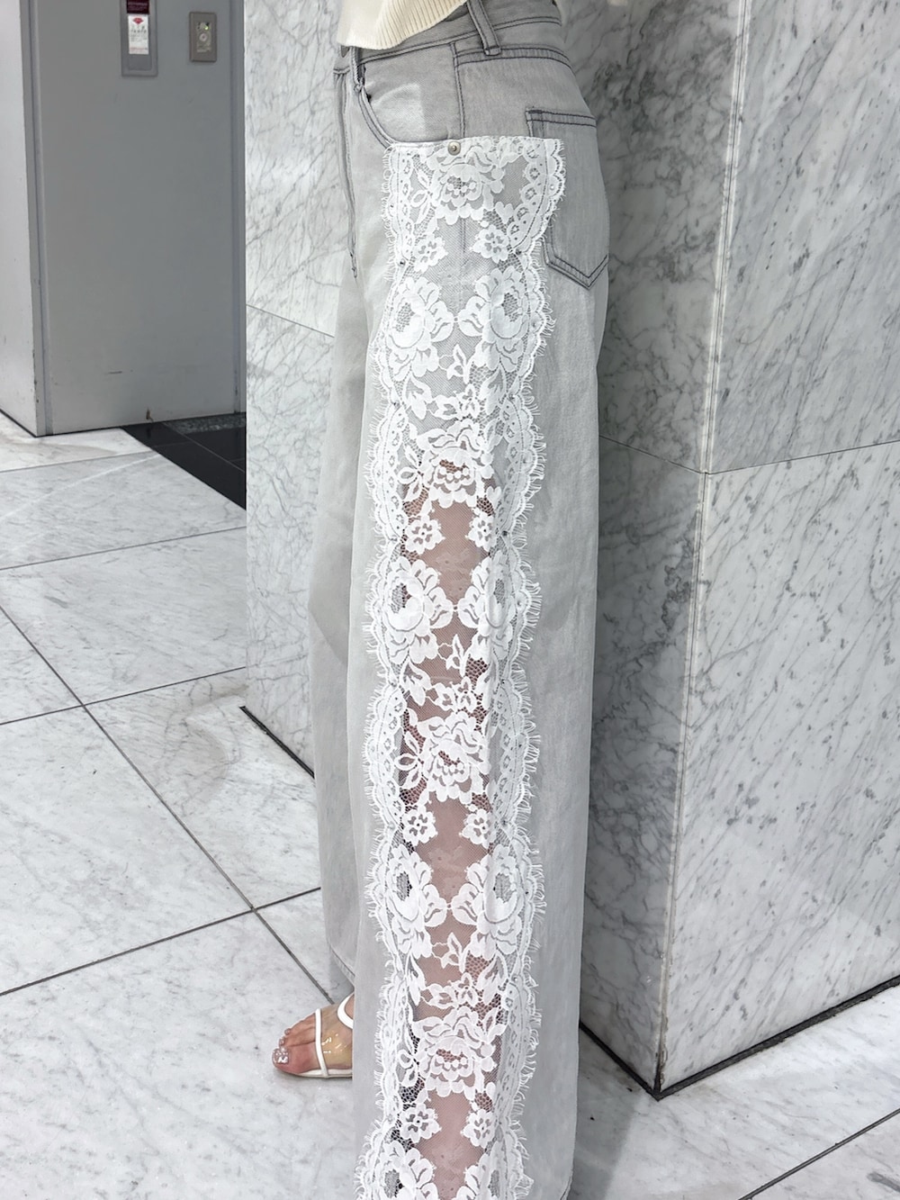 グレー系のデニムパンツ、ホワイト系のニット/セーター、ホワイト系のサンダルを着用したレディースの夏コーディネートの7枚目の写真
