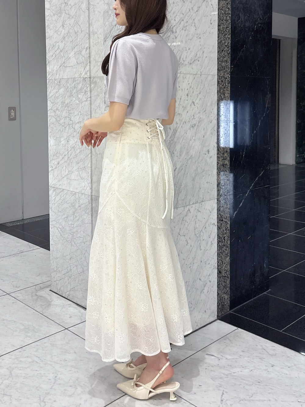 ホワイト系のスカート、グレー系のニット/セーター、ホワイト系のパンプスを着用したレディースの春コーディネートの3枚目の写真