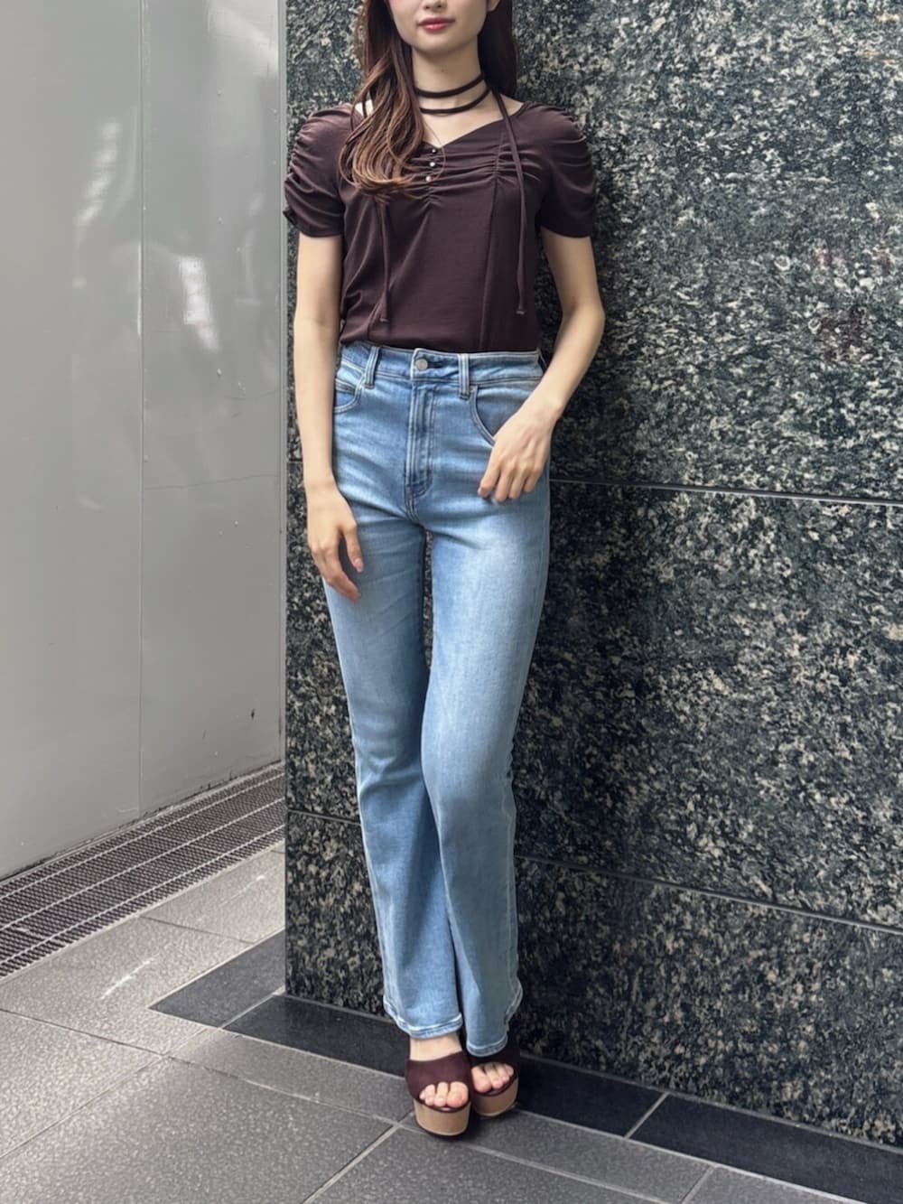 ブルー系のデニムパンツ、ブラウン系のTシャツ/カットソー、ブラウン系のサンダルを着用したレディースの春コーディネートの2枚目の写真