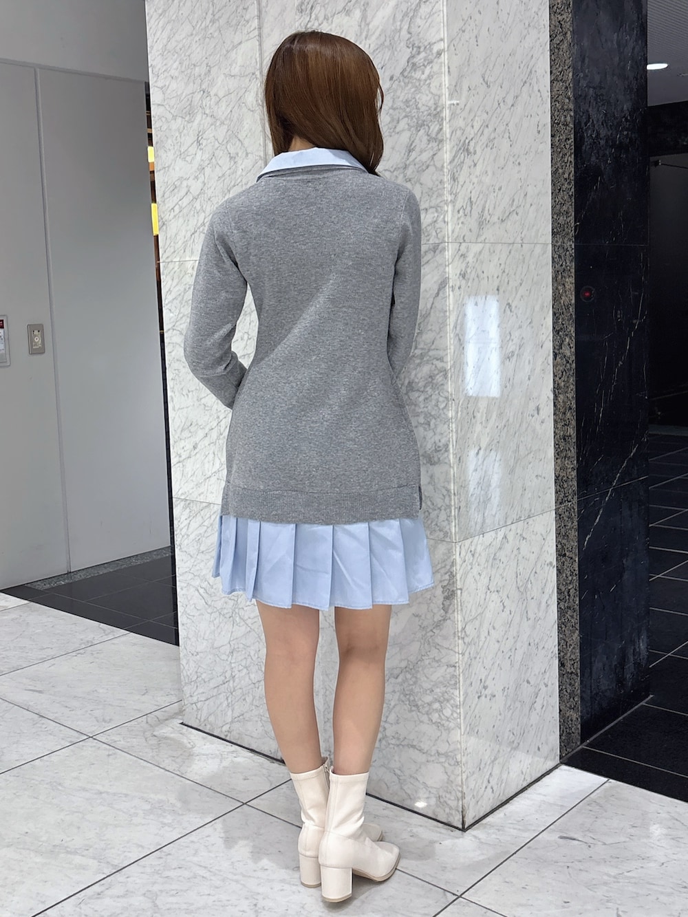 グレー系のワンピース、ホワイト系のブーツを着用したレディースの秋コーディネートの3枚目の写真