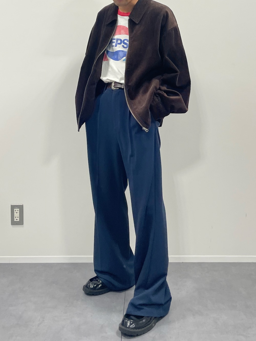 ブラウン系のブルゾン、ブルー系のスラックス、ブラック系のその他シューズを着用したメンズの秋コーディネートの2枚目の写真