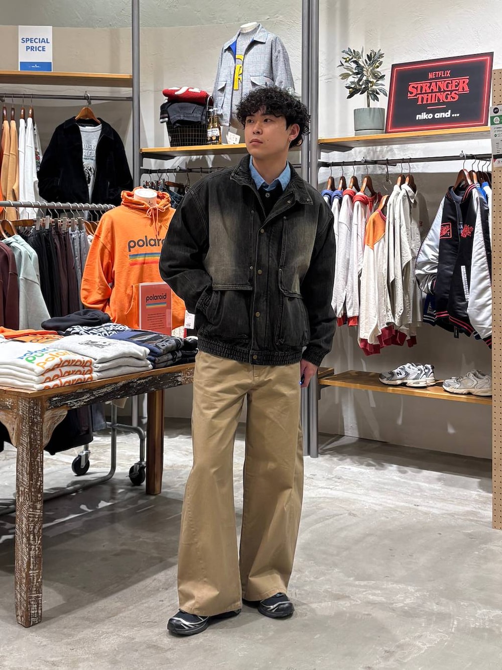 グレー系のブルゾン、ベージュ系のチノパンツを着用したメンズの冬コーディネートの2枚目の写真