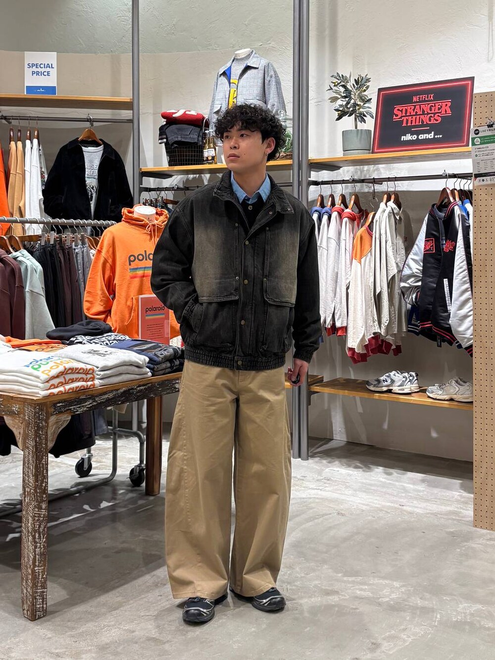 グレー系のブルゾン、ベージュ系のチノパンツを着用したメンズの冬コーディネートの7枚目の写真