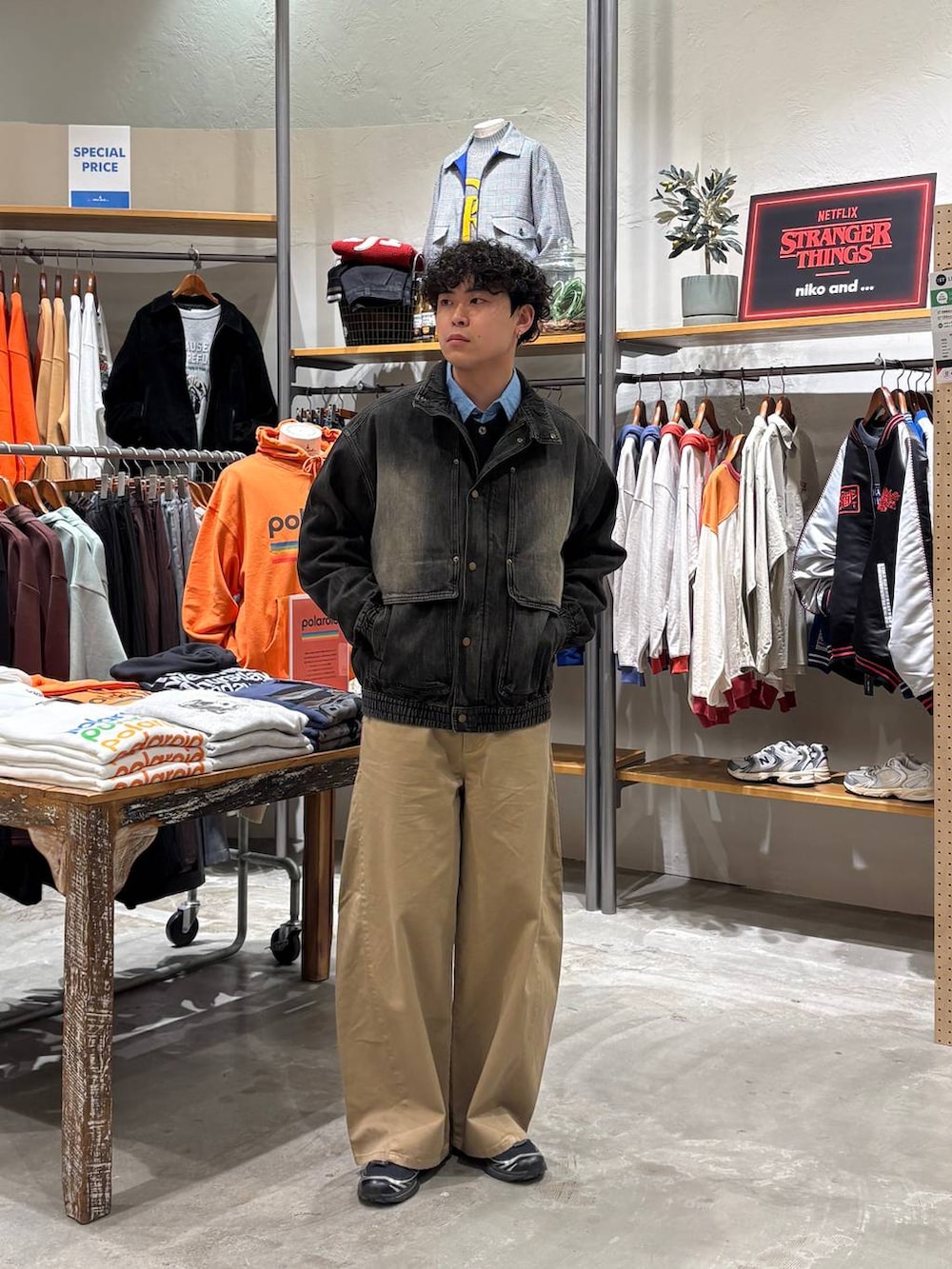 グレー系のブルゾン、ベージュ系のチノパンツを着用したメンズの冬コーディネートの3枚目の写真