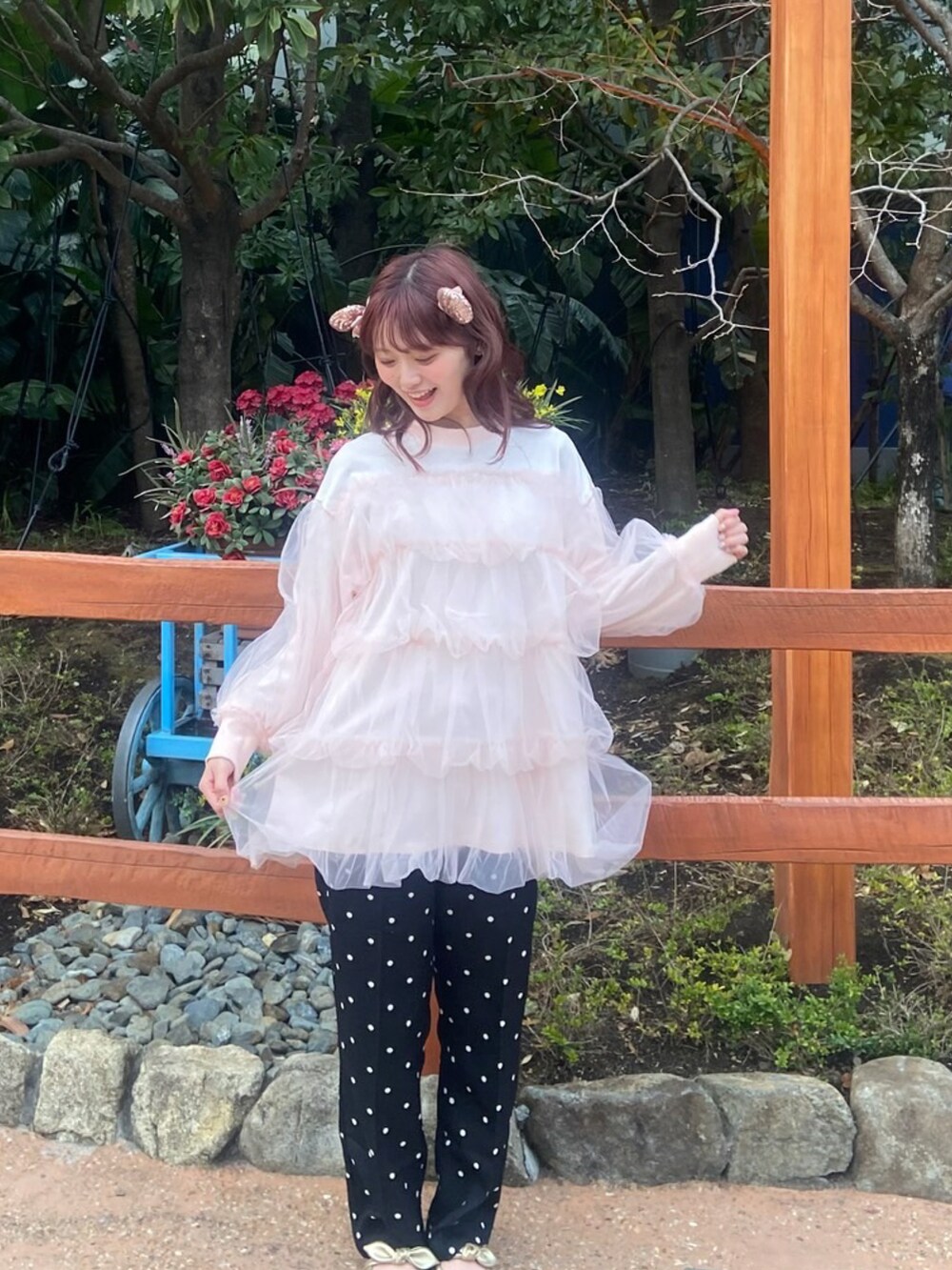ピンク系のスウェット、ブラック系のスラックスを着用したレディースの春コーディネートの2枚目の写真