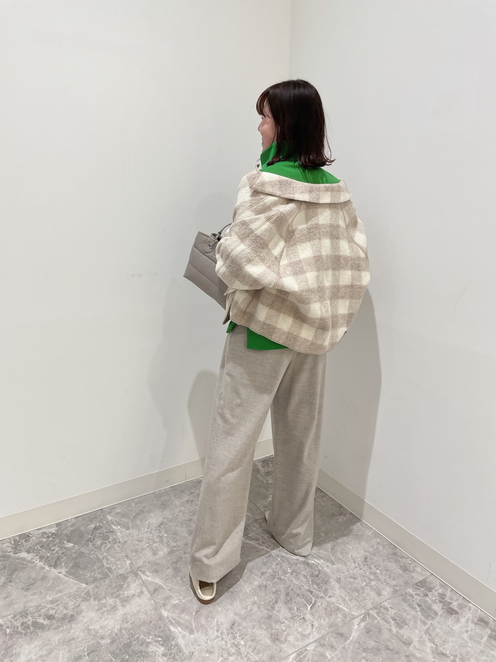 グリーン系のスウェット、ベージュ系のパンツ、ベージュ系のシューズを着用したレディースの秋コーディネートの3枚目の写真