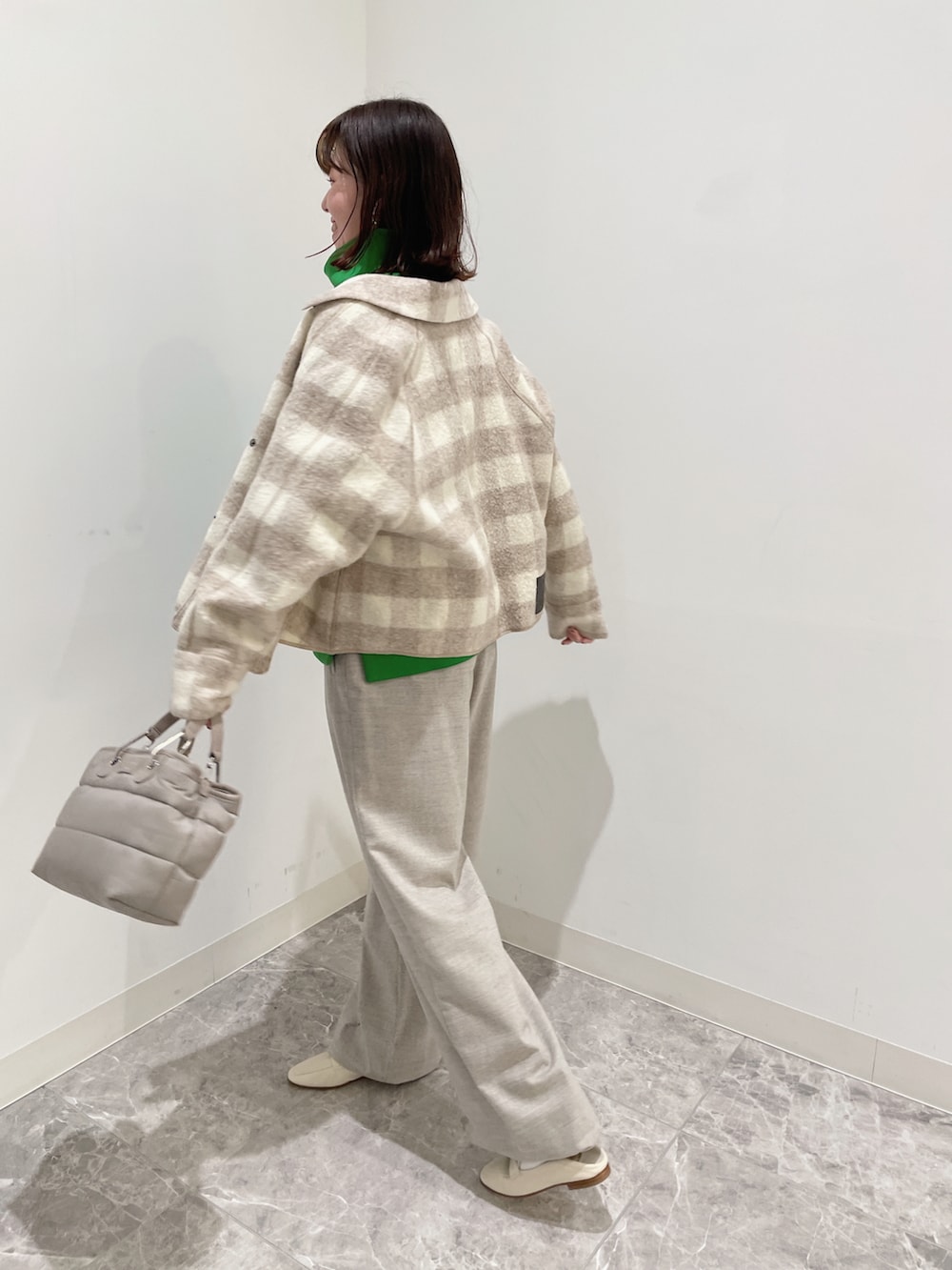 グリーン系のスウェット、ベージュ系のパンツ、ベージュ系のシューズを着用したレディースの秋コーディネートの2枚目の写真