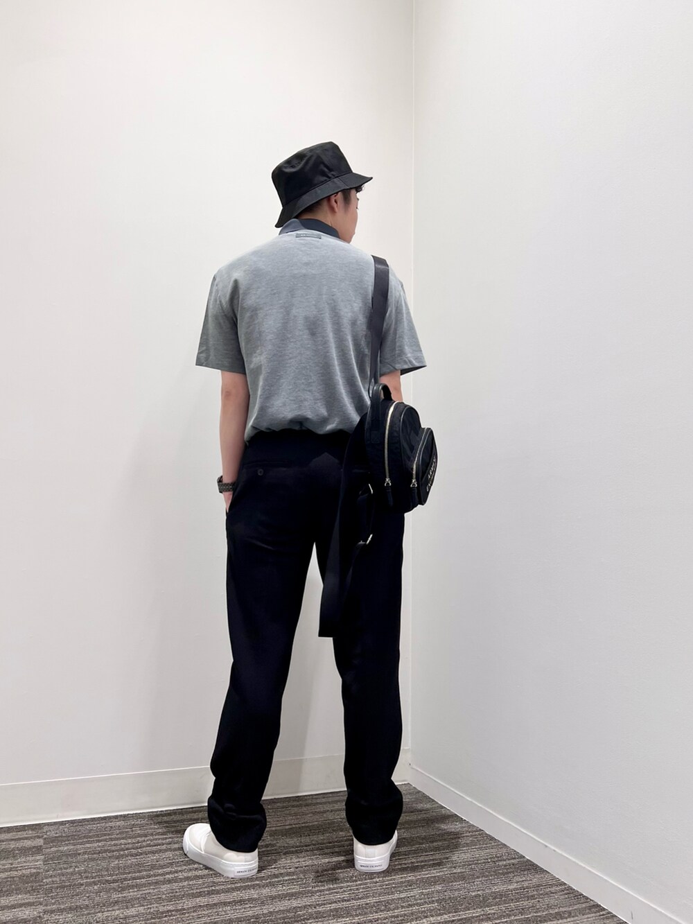 グリーン系のポロシャツ、ブルー系のスラックス、ホワイト系のスニーカーを着用したメンズの夏コーディネートの2枚目の写真