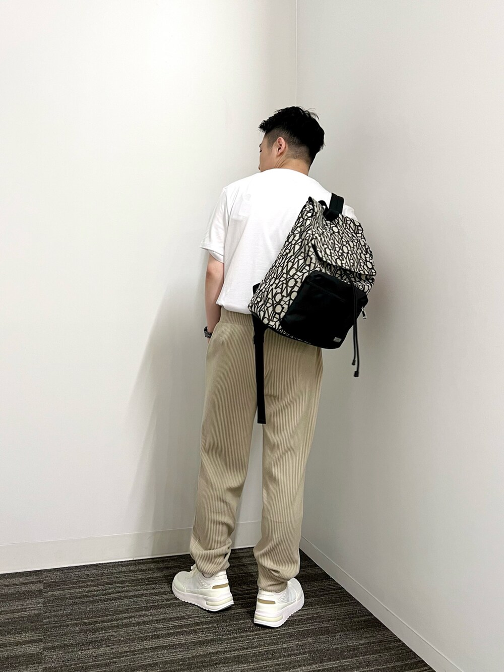 ホワイト系のTシャツ/カットソー、ベージュ系のスウェットパンツ、ホワイト系のバックパック/リュックを着用したメンズの夏コーディネートの2枚目の写真