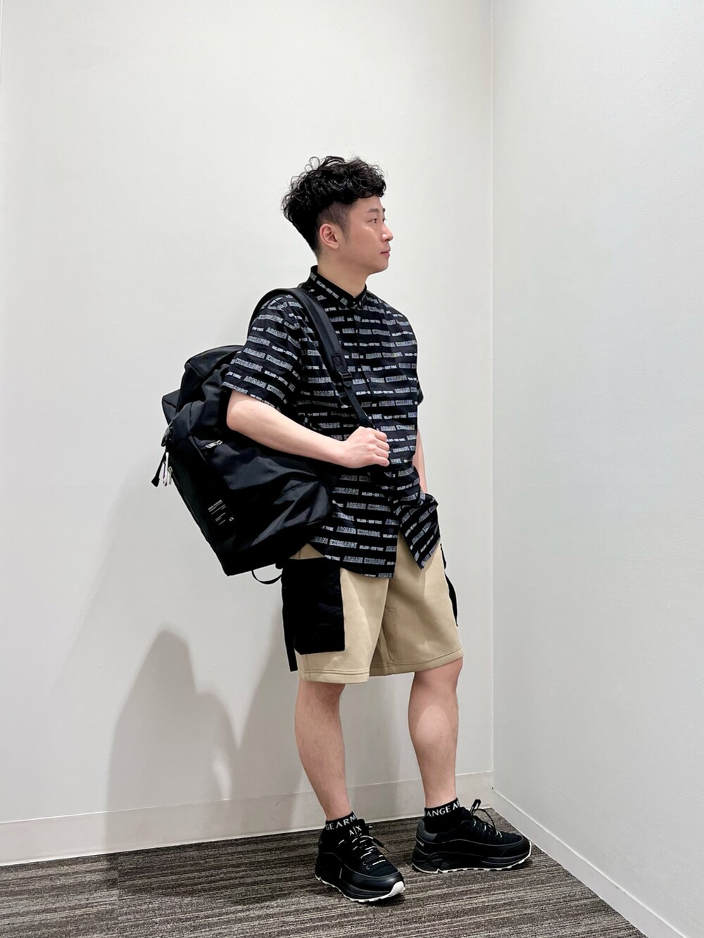 ブラック系のバックパック/リュック、ブラック系のシャツ/ブラウス、ベージュ系のその他パンツを着用したメンズの夏コーディネートの2枚目の写真