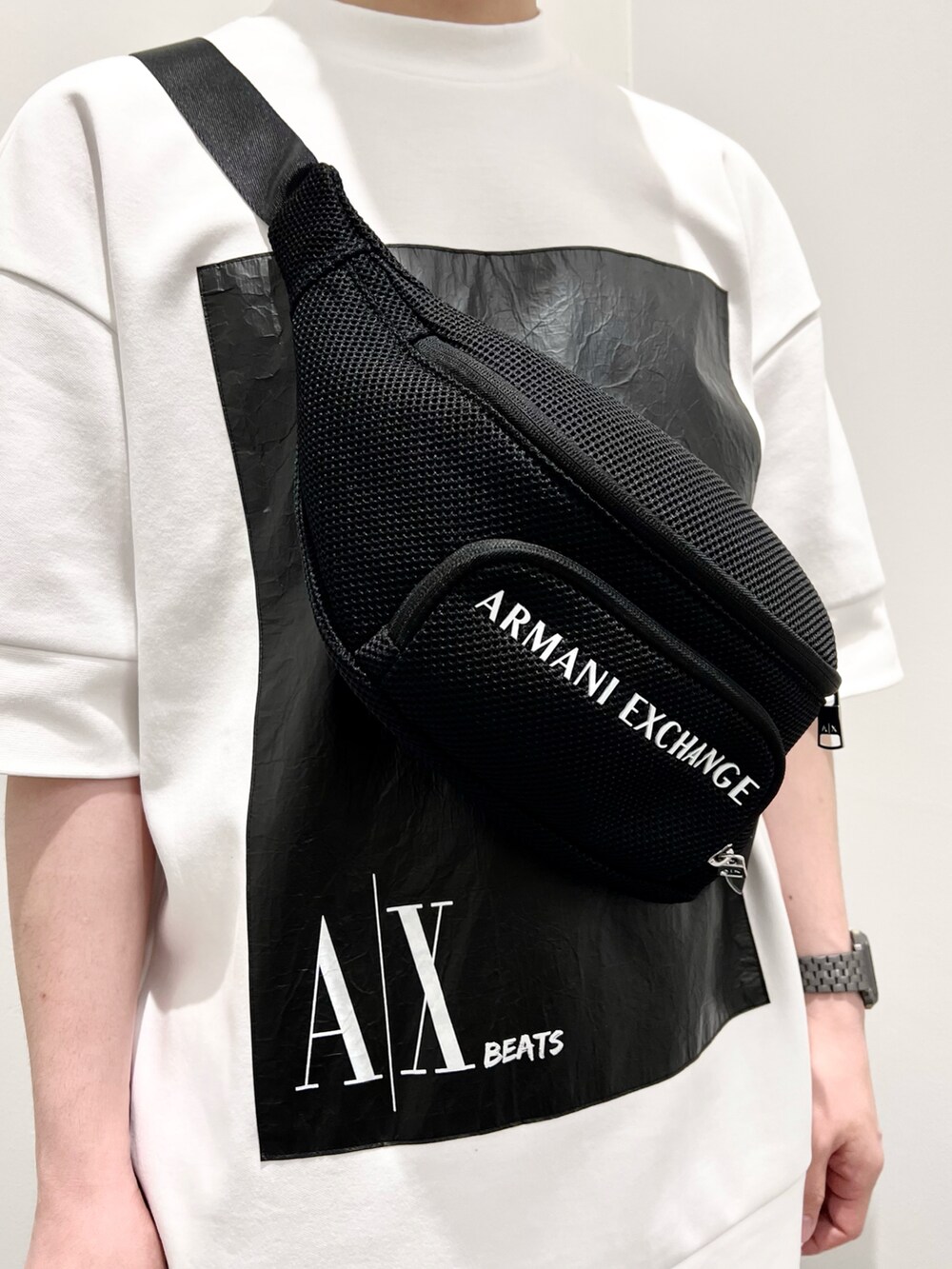 ブラック系のボディバッグ/ウエストポーチ、ホワイト系のスウェット、ブルー系のデニムパンツを着用したメンズの夏コーディネートの3枚目の写真