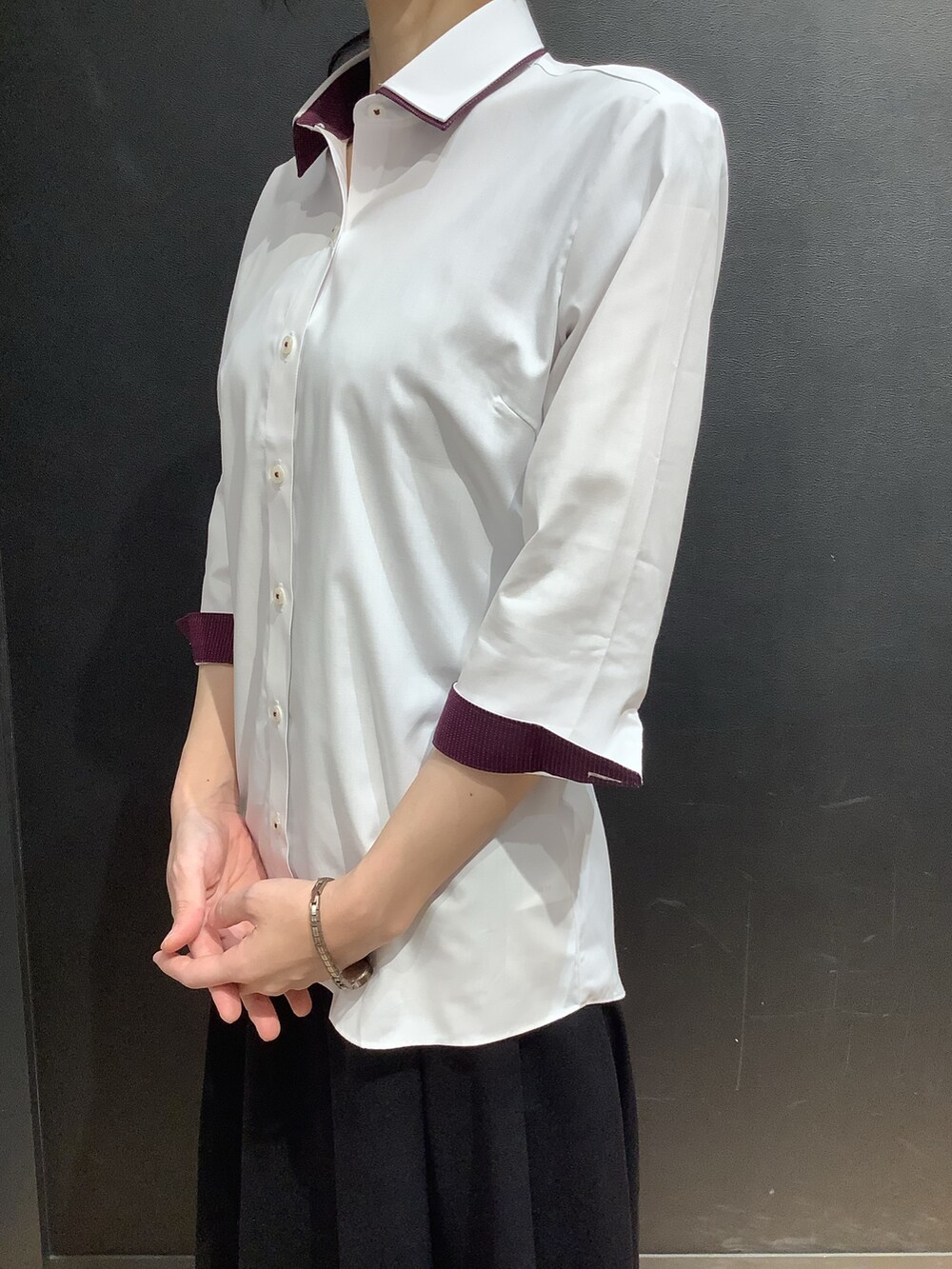 ホワイト系のビジネスシャツを着用したレディースの夏コーディネートの2枚目の写真