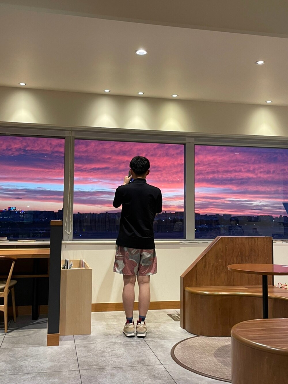 ブラック系のポロシャツ、ピンク系のショーツを着用したメンズの夏コーディネートの2枚目の写真