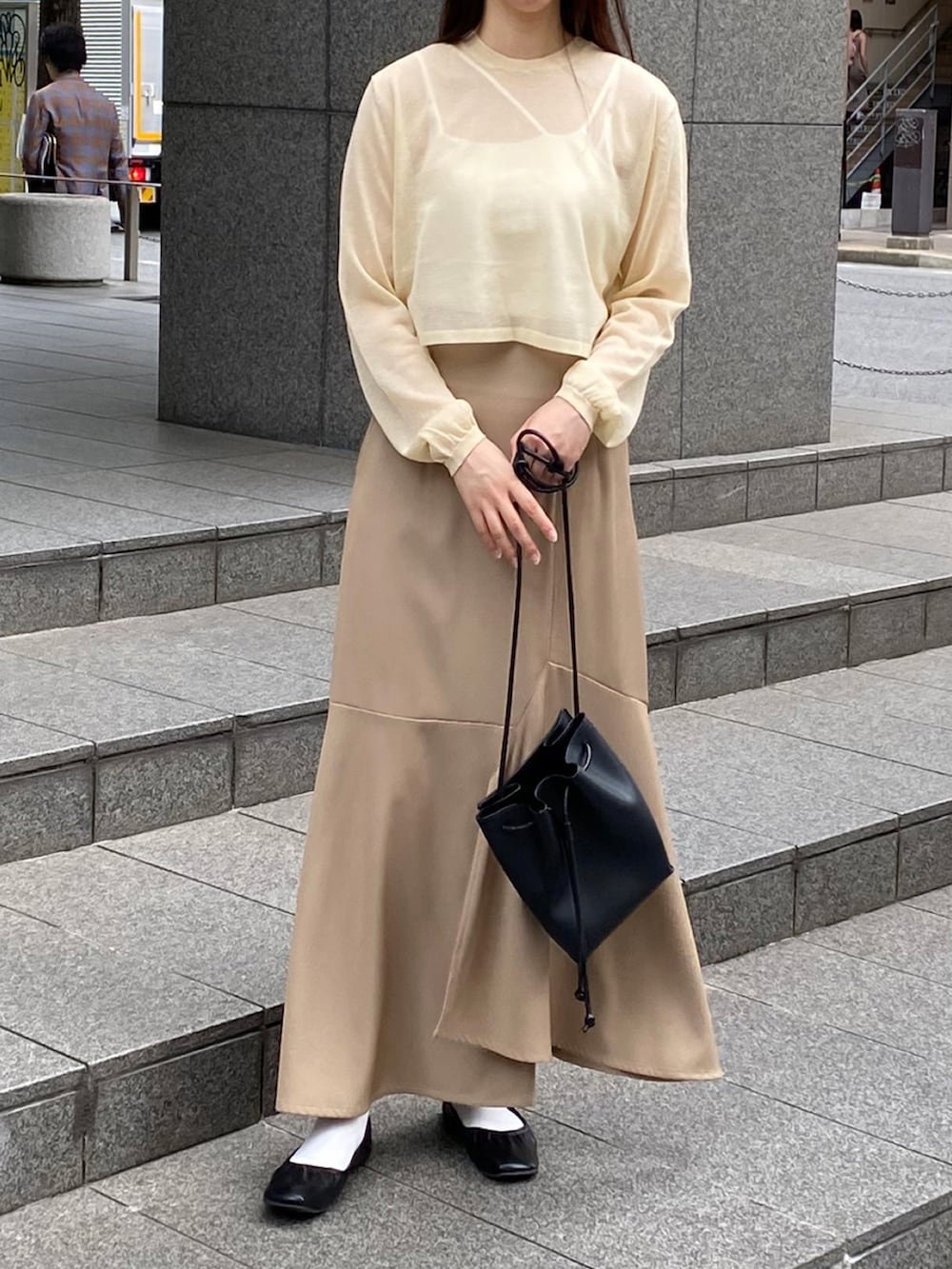 ホワイト系のニット/セーター、ベージュ系のスカートを着用したレディースの秋コーディネートの2枚目の写真
