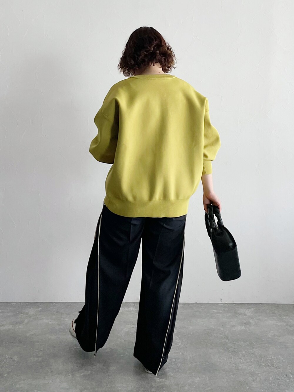 イエロー系のカーディガン/ボレロ、ブラック系のショルダーバッグ、ブラック系のスラックスを着用したレディースの夏コーディネートの3枚目の写真