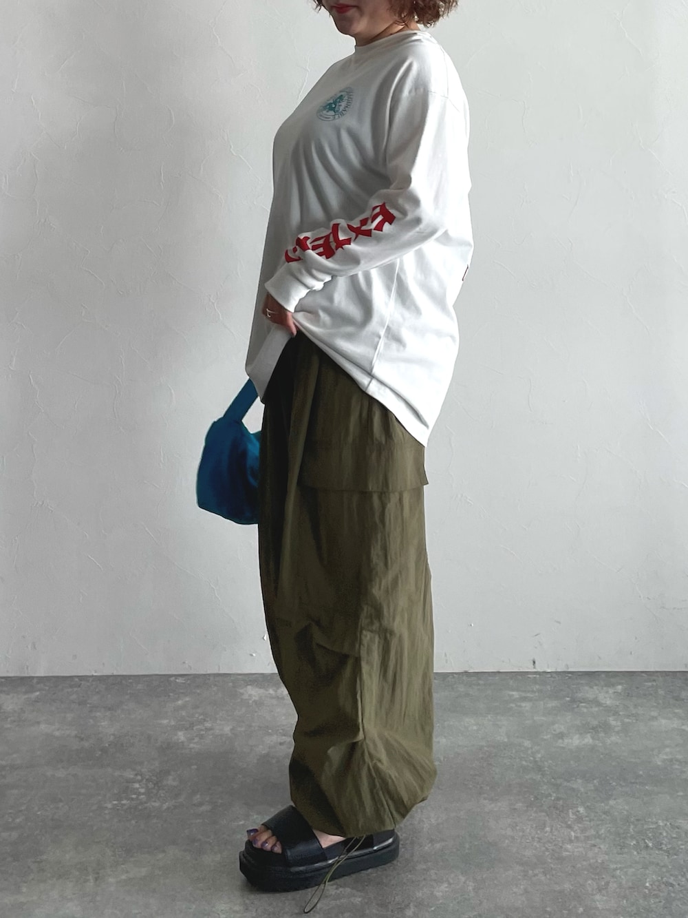 ホワイト系のTシャツ/カットソー、グリーン系のその他パンツ、ブルー系のハンドバッグを着用したレディースの夏コーディネートの2枚目の写真