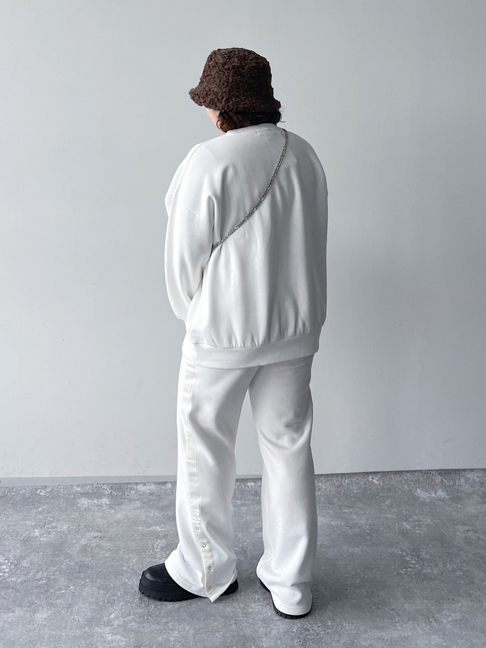 ホワイト系のスウェット、ホワイト系のスウェットパンツ、ブラック系のブーツを着用したレディースの冬コーディネートの2枚目の写真