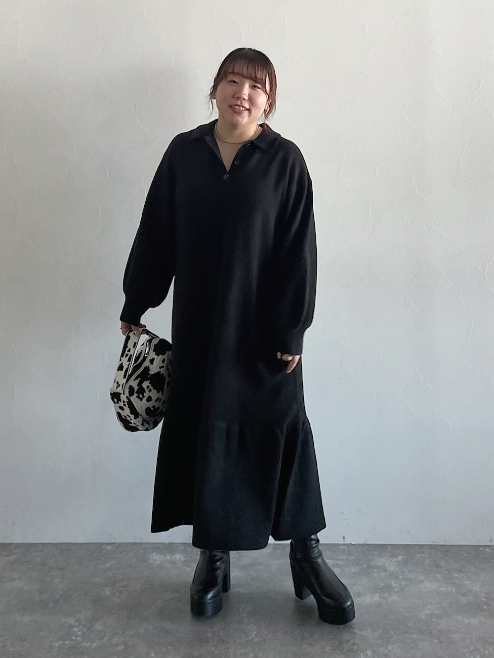 ブラック系のハンドバッグ、ブラック系のワンピース、ブラック系のブーツを着用したレディースの秋コーディネートの2枚目の写真