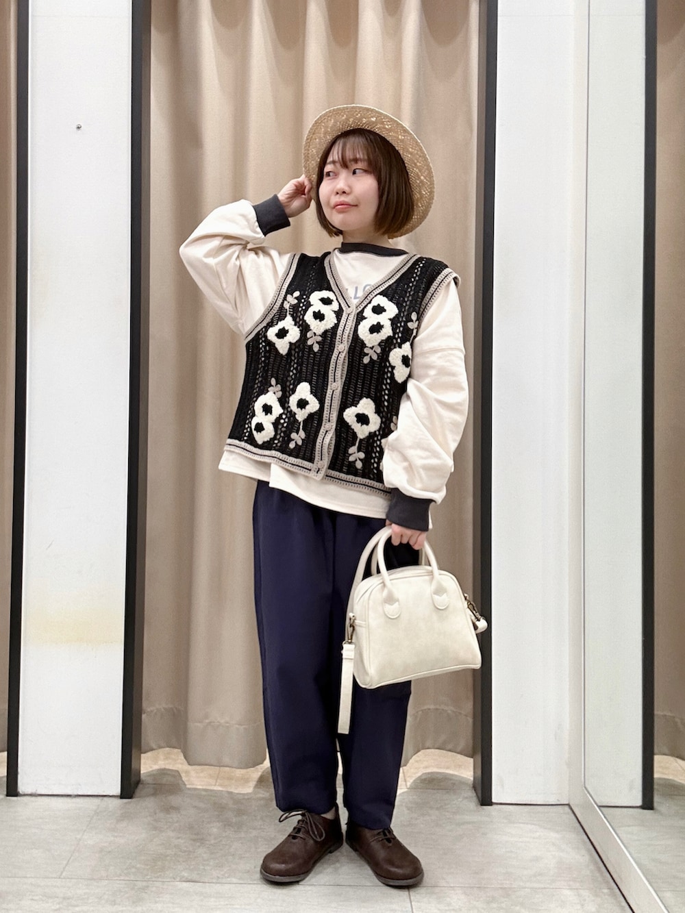 ブラック系のベスト、ブルー系のその他パンツ、ブラウン系のドレスシューズを着用したレディースの春コーディネートの2枚目の写真