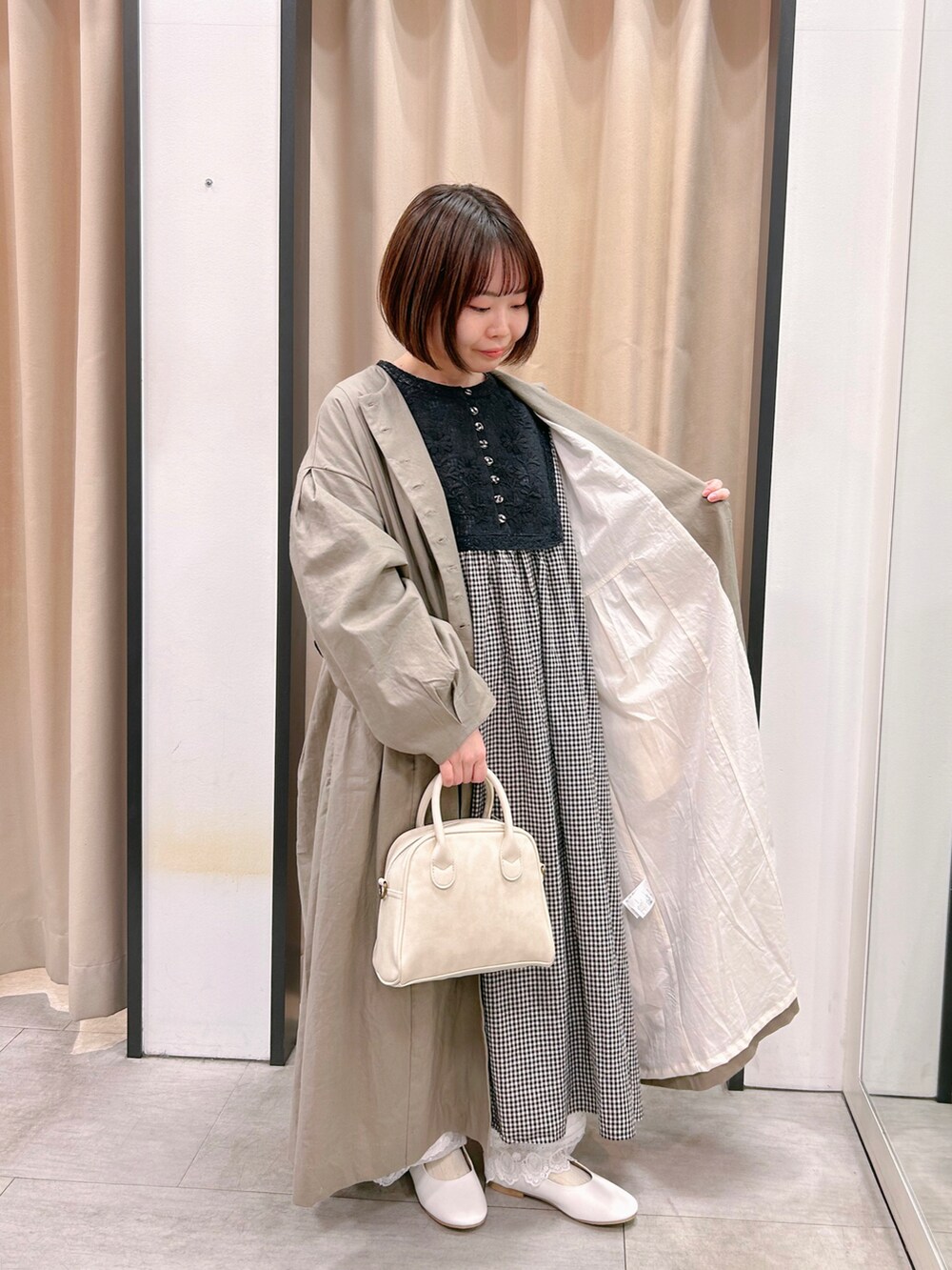 グレー系のワンピース、ホワイト系のドレスシューズ、ホワイト系のパンツを着用したレディースの冬コーディネートの2枚目の写真
