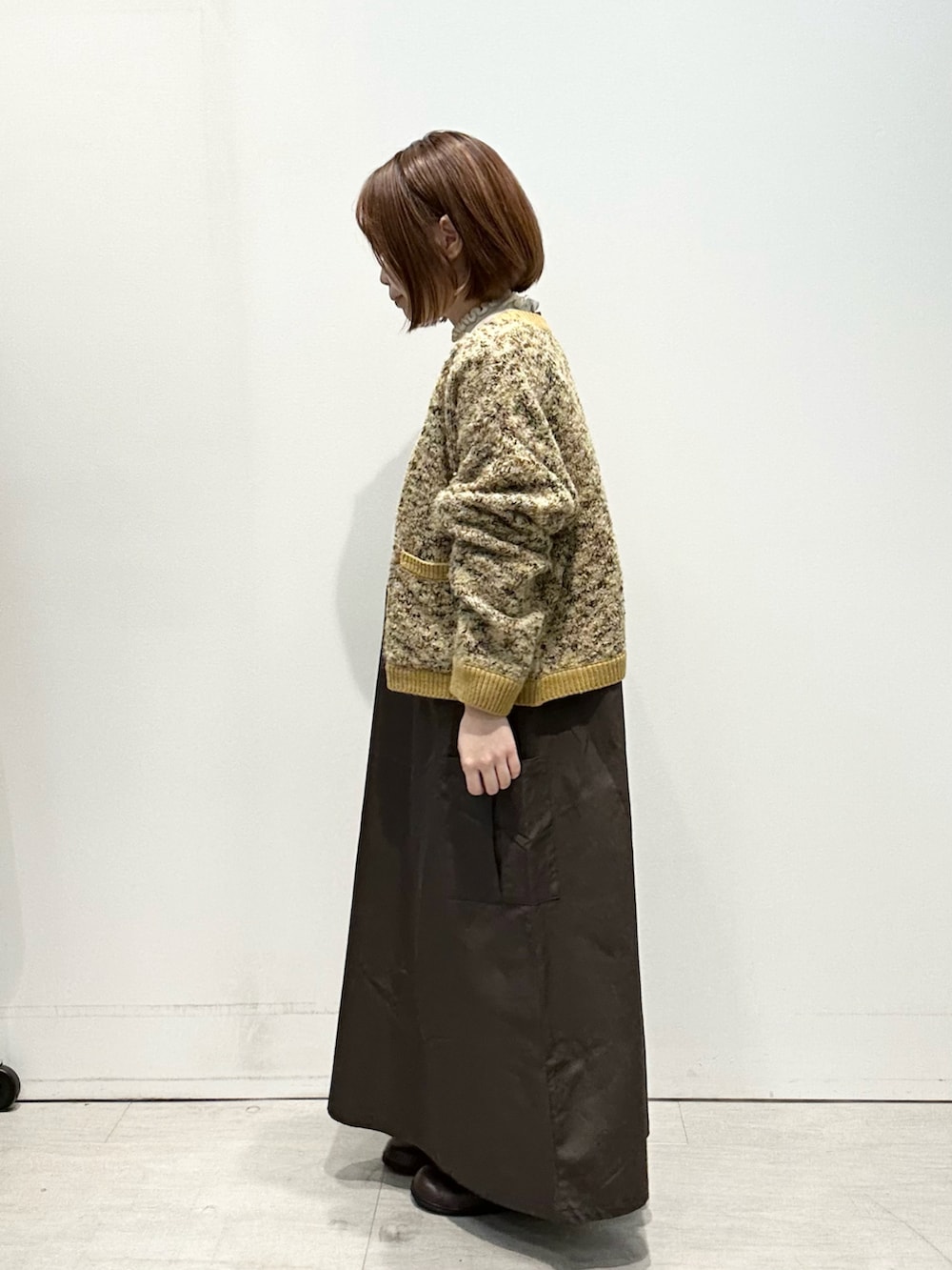 ホワイト系のニット/セーター、ブラウン系のワンピース、イエロー系のカーディガン/ボレロを着用したレディースの秋コーディネートの2枚目の写真