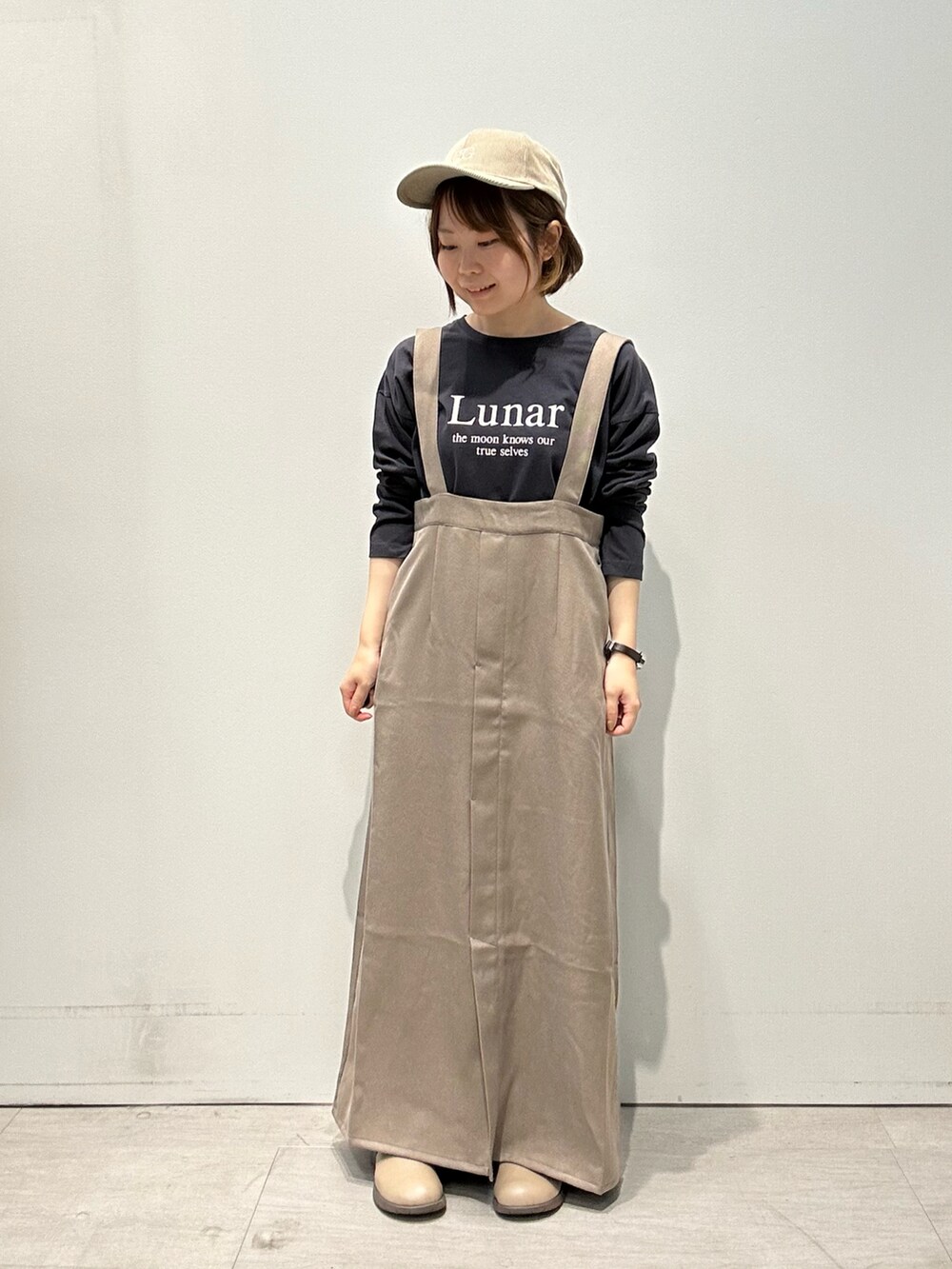 グレー系のTシャツ/カットソー、グリーン系のワンピース、ホワイト系のハンドバッグを着用したレディースの秋コーディネートの2枚目の写真