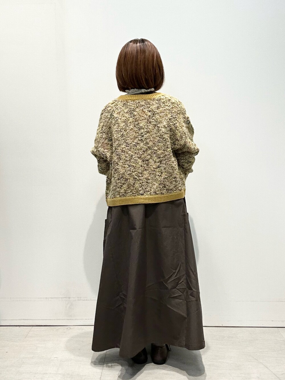 ホワイト系のニット/セーター、ブラウン系のワンピース、イエロー系のカーディガン/ボレロを着用したレディースの秋コーディネートの3枚目の写真