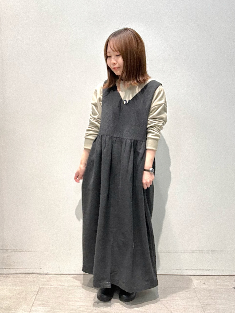 ブラック系のワンピース、グリーン系のTシャツ/カットソー、ベージュ系のハットを着用したレディースの冬コーディネートの3枚目の写真