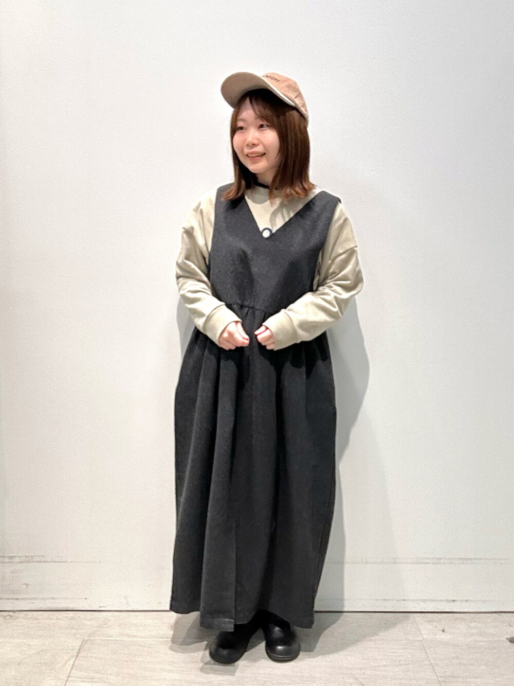 ブラック系のワンピース、グリーン系のTシャツ/カットソー、ベージュ系のハットを着用したレディースの冬コーディネートの2枚目の写真