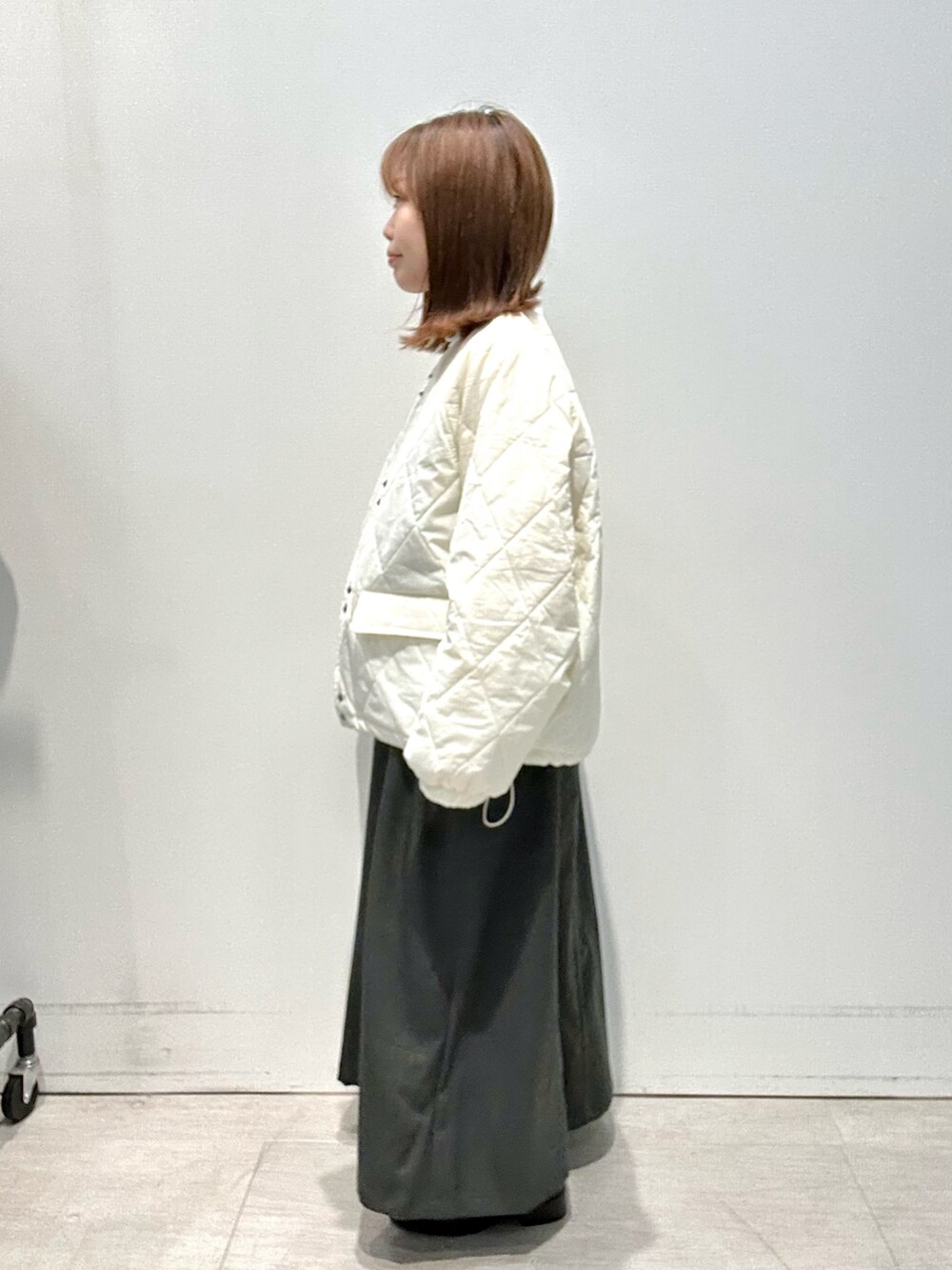 グレー系のワンピース、ホワイト系のジャケット/アウター、ホワイト系のニット/セーターを着用したレディースの冬コーディネートの2枚目の写真