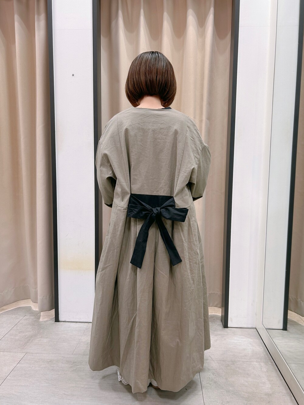 グレー系のワンピース、ホワイト系のドレスシューズ、ホワイト系のパンツを着用したレディースの冬コーディネートの3枚目の写真