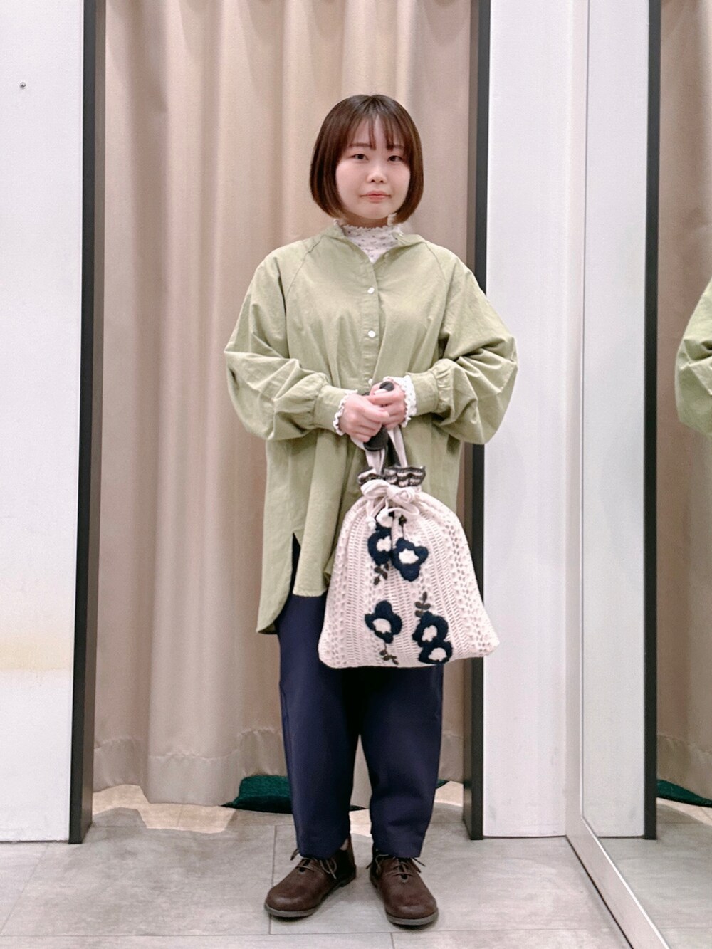 ホワイト系のTシャツ/カットソー、グリーン系のチュニック、ホワイト系のハンドバッグを着用したレディースの冬コーディネートの2枚目の写真