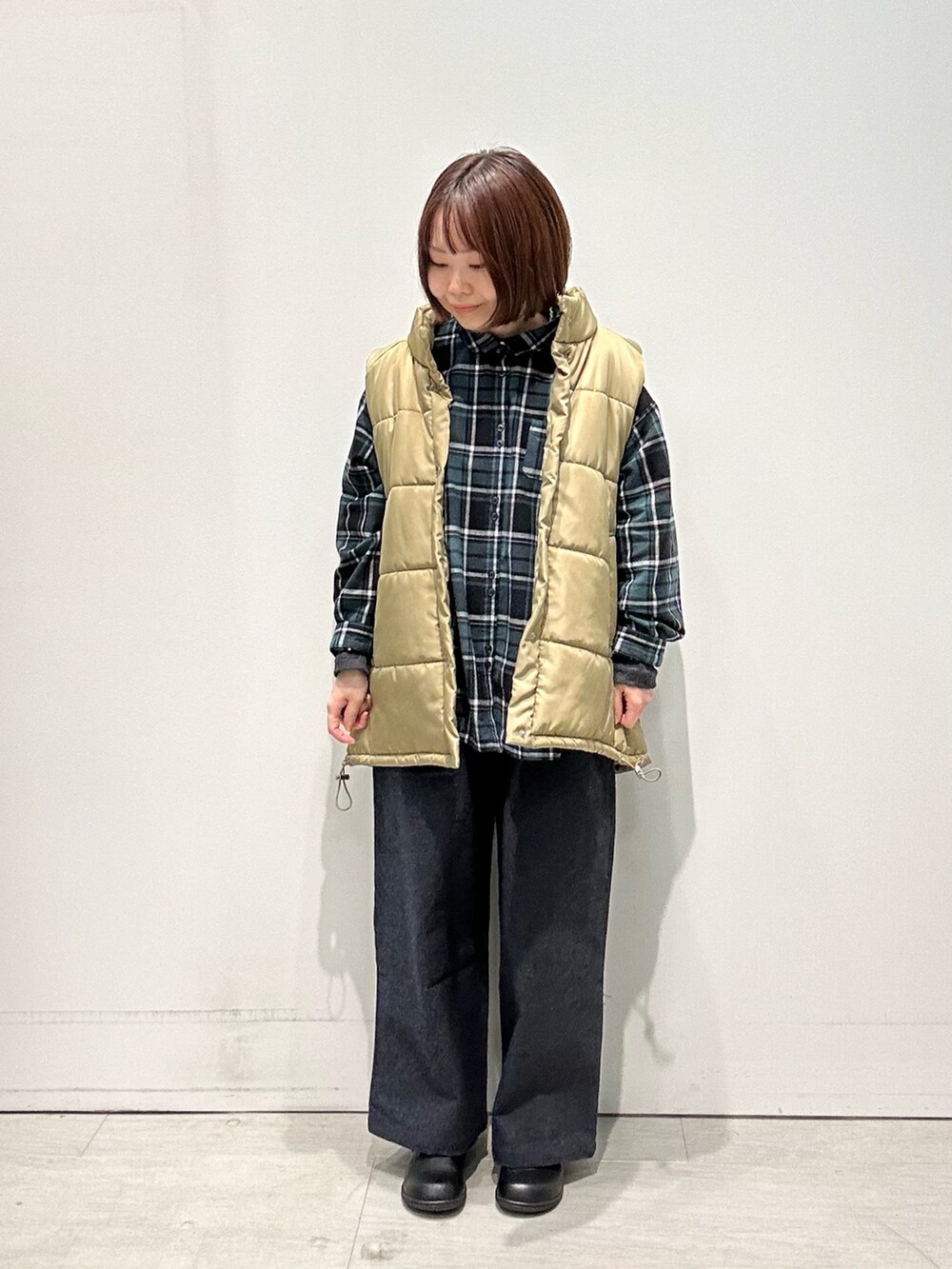 ブルー系のシャツ/ブラウス、ベージュ系のベスト、グレー系のその他パンツを着用したレディースの秋コーディネートの4枚目の写真